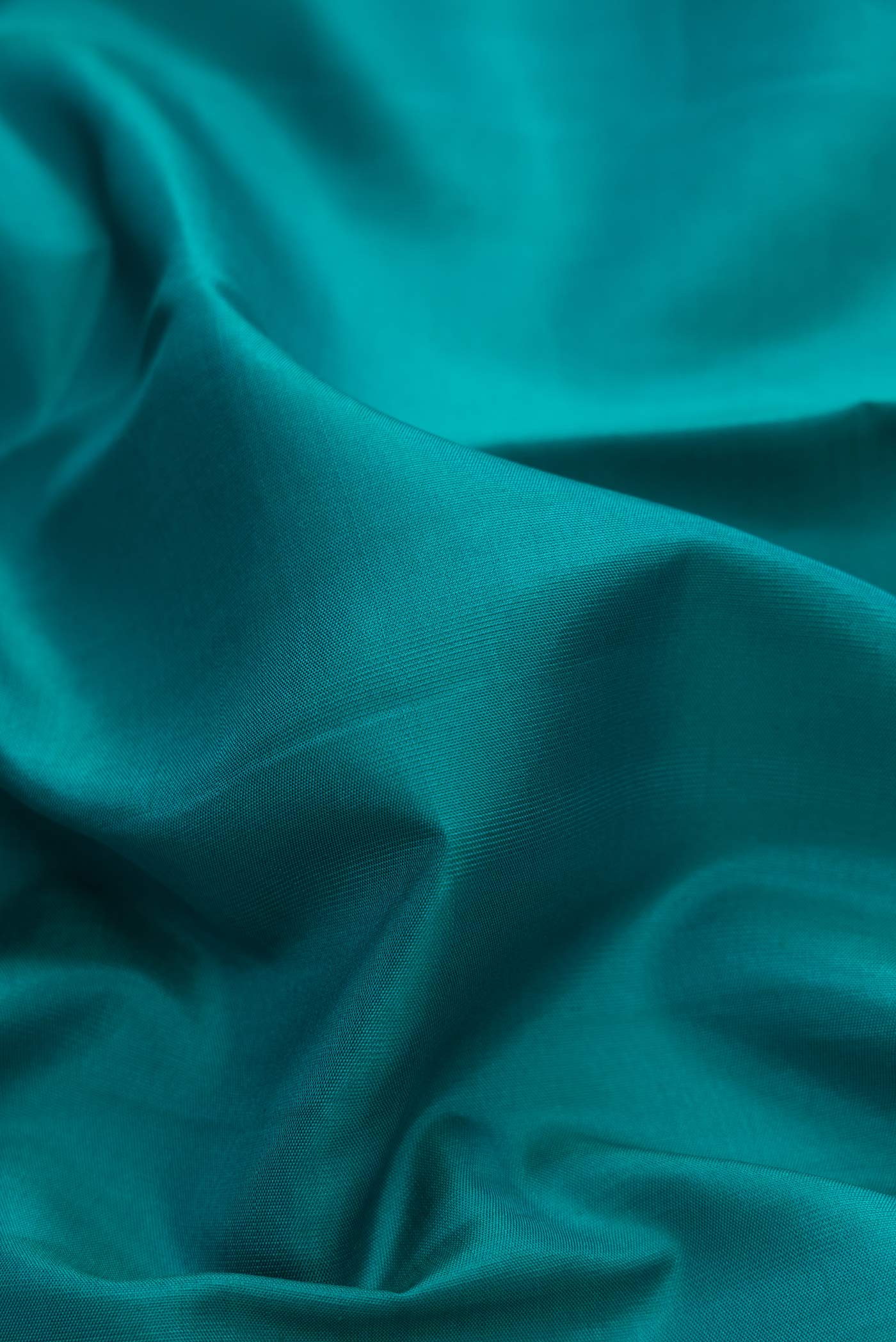 Close up of Pure Silk Pure Zari Green Dual Tone Kanchipuram Saree with Plain Body and Zari Border displaying folds