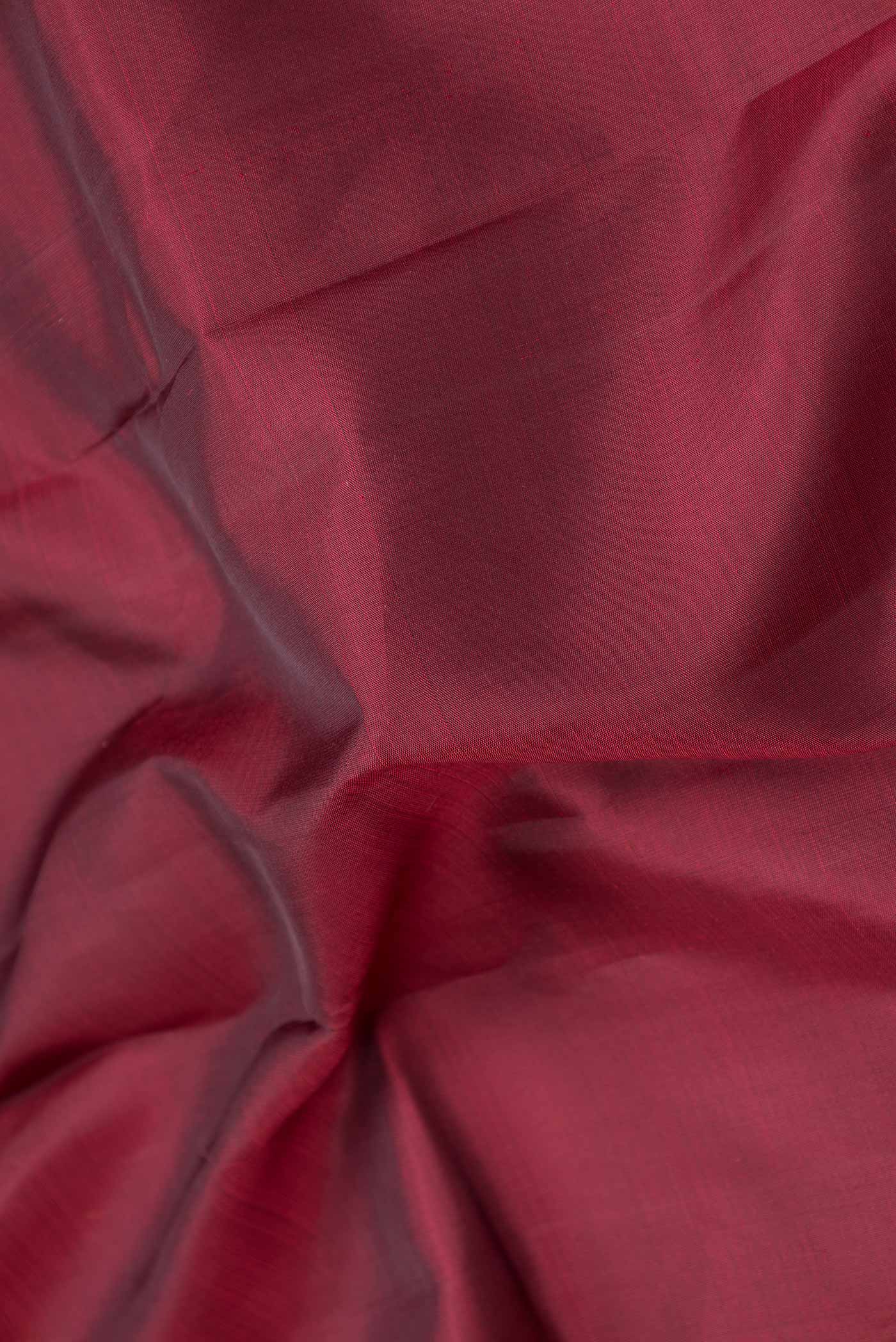 Close up of Pure Silk Pure Zari Maroon Dual Tone Kanchipuram Saree with Plain Body and Zari Border displaying folds