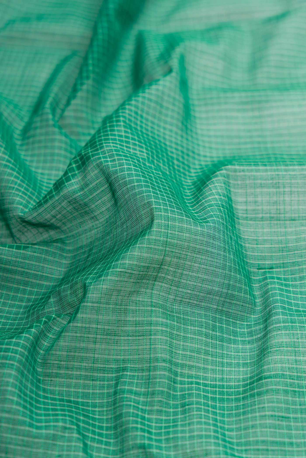 Close up of Green Gadwal cotton Saree with Checked design on the body and Zari Border displaying folds