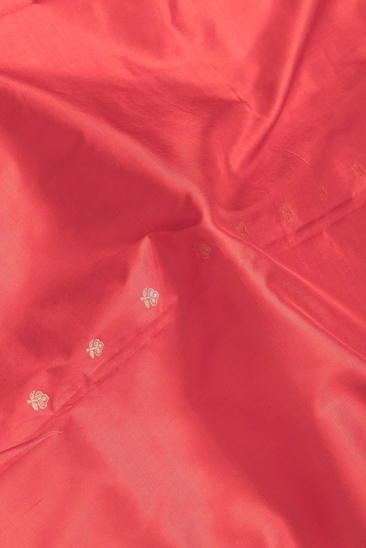 Close up of Red Dual Tone Banarasi Silk Saree with Zari Butta on the body and Zari Border.  displaying folds