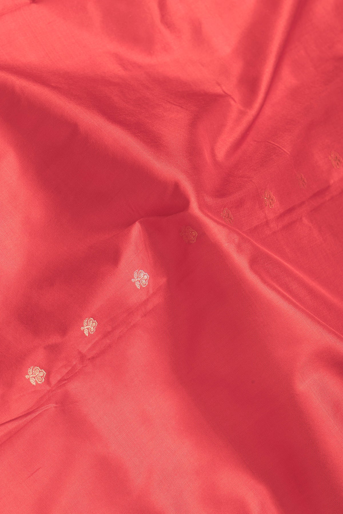 Close up of Red Dual Tone Banarasi Silk Saree with Zari Butta on the body and Zari Border.  displaying folds