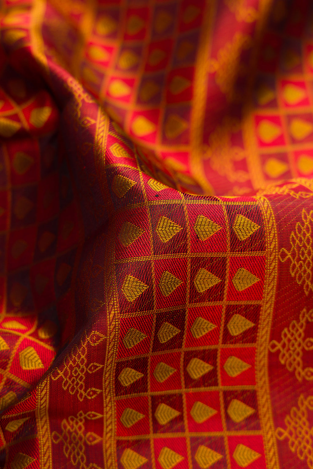 Close up of Maroon Kanjivaram Silk Saree with Jacquard design on the body and Thread Border.  displaying folds
