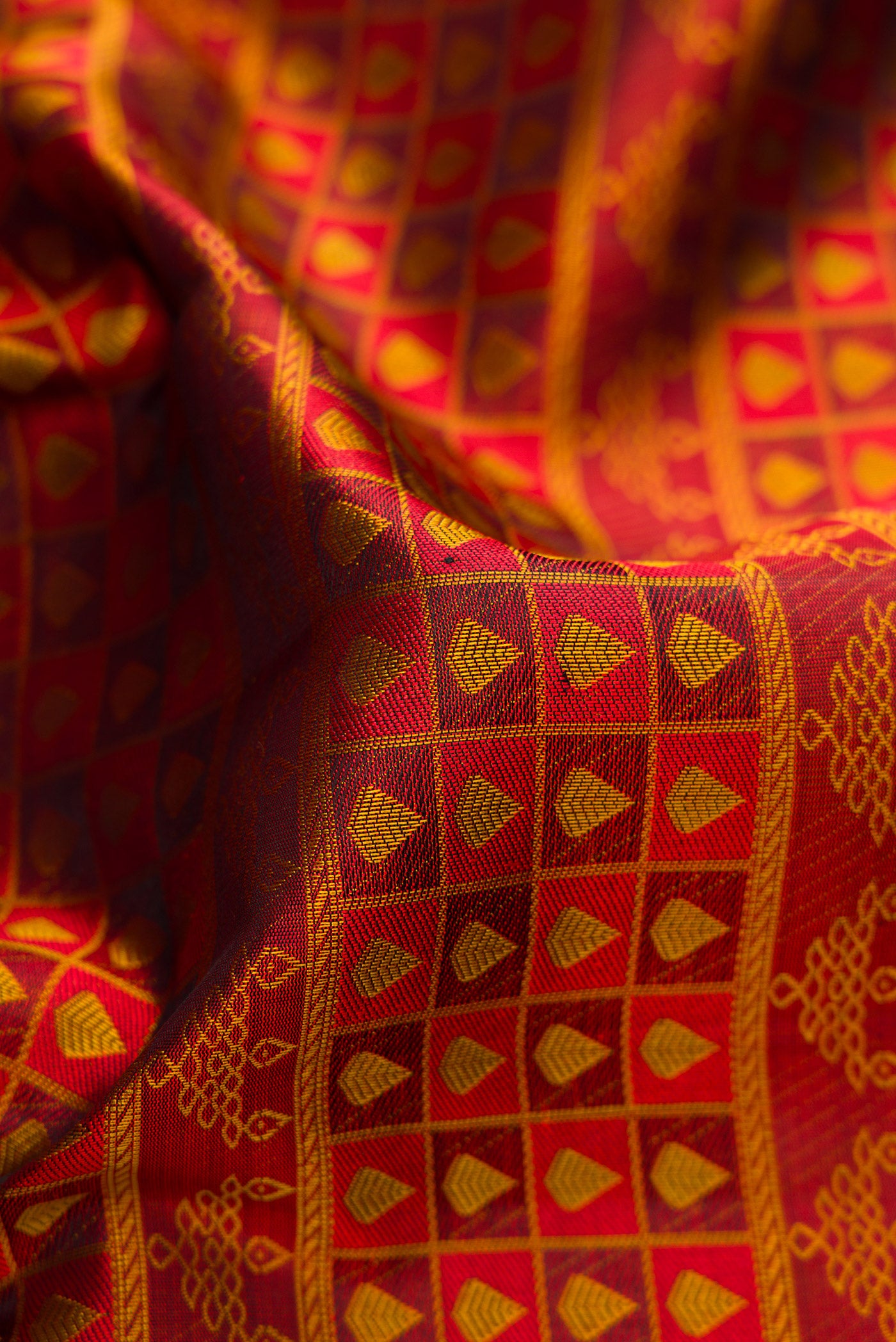 Close up of Maroon Kanjivaram Silk Saree with Jacquard design on the body and Thread Border.  displaying folds