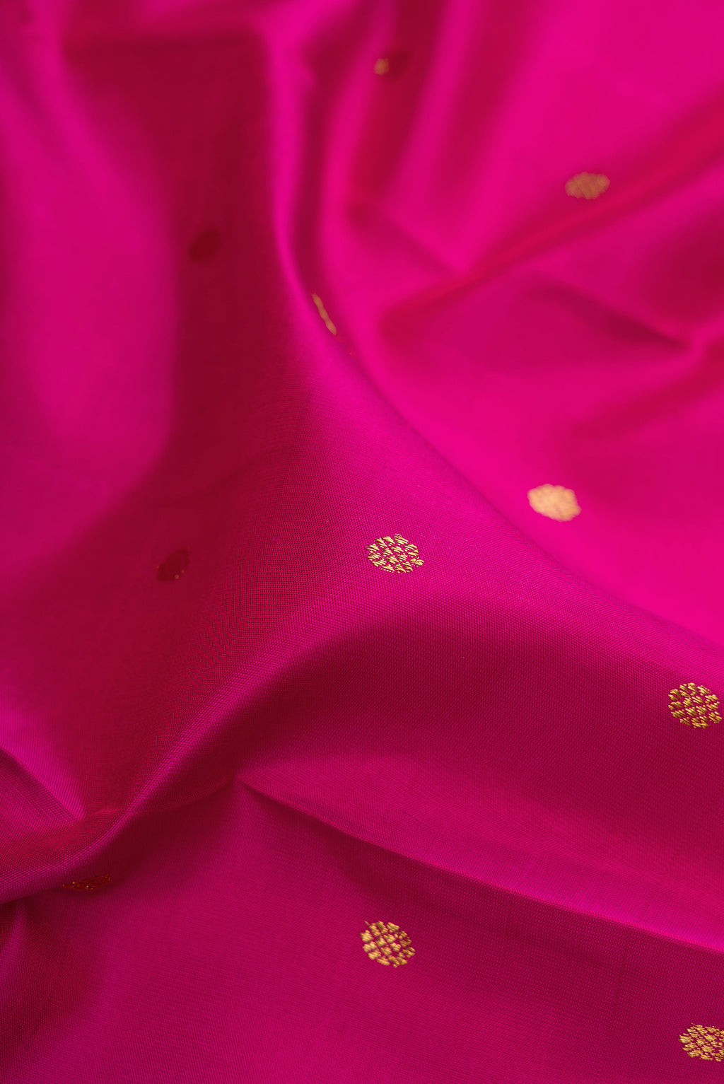 Close up of Pure Silk Pure Zari Magenta Kanjivaram Saree with Zari Butta on the body and Zari Border.  displaying folds