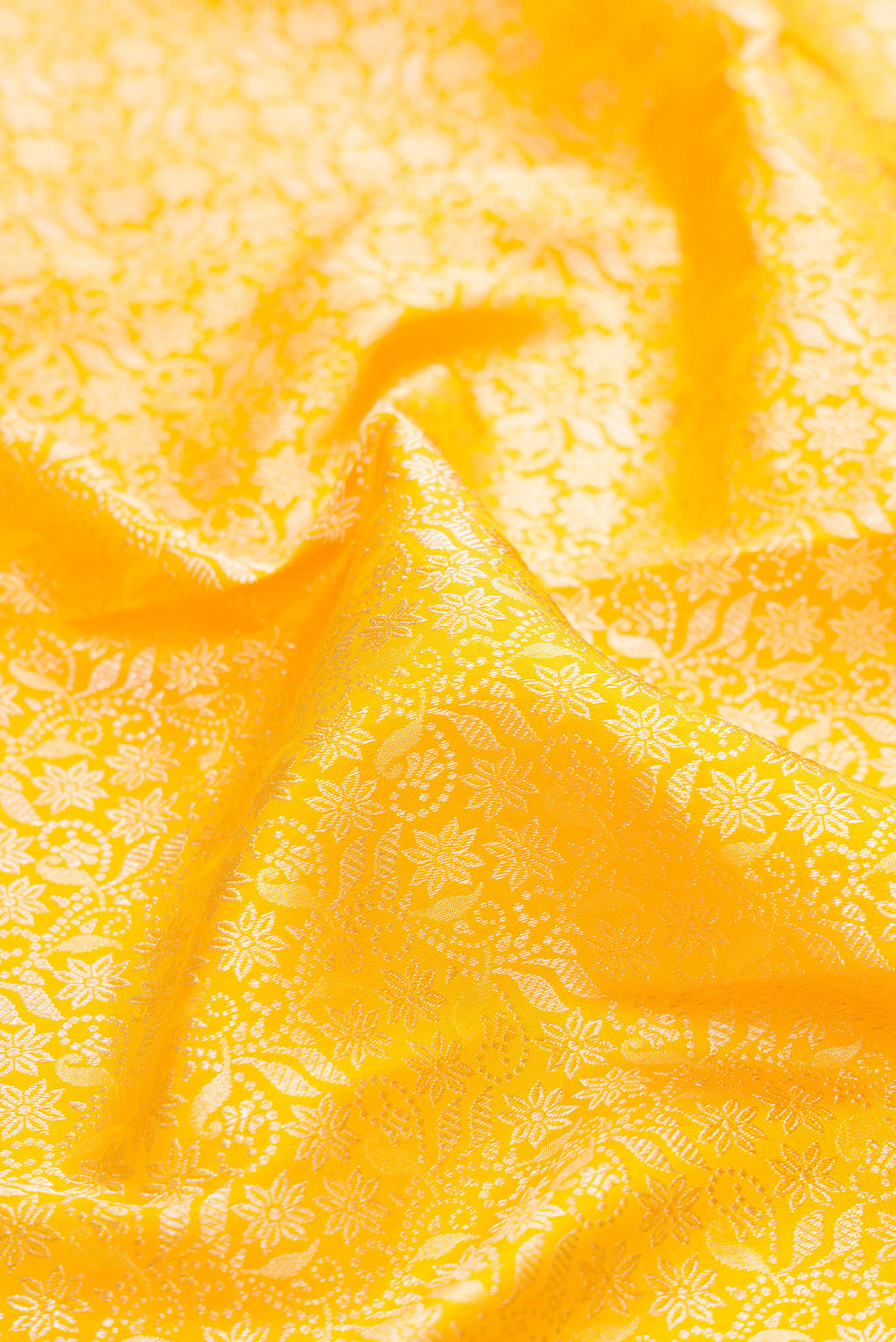 Close up of Yellow Kanchipuram Silk Saree with Zari Brocade on the body and Fancy Border.  displaying folds