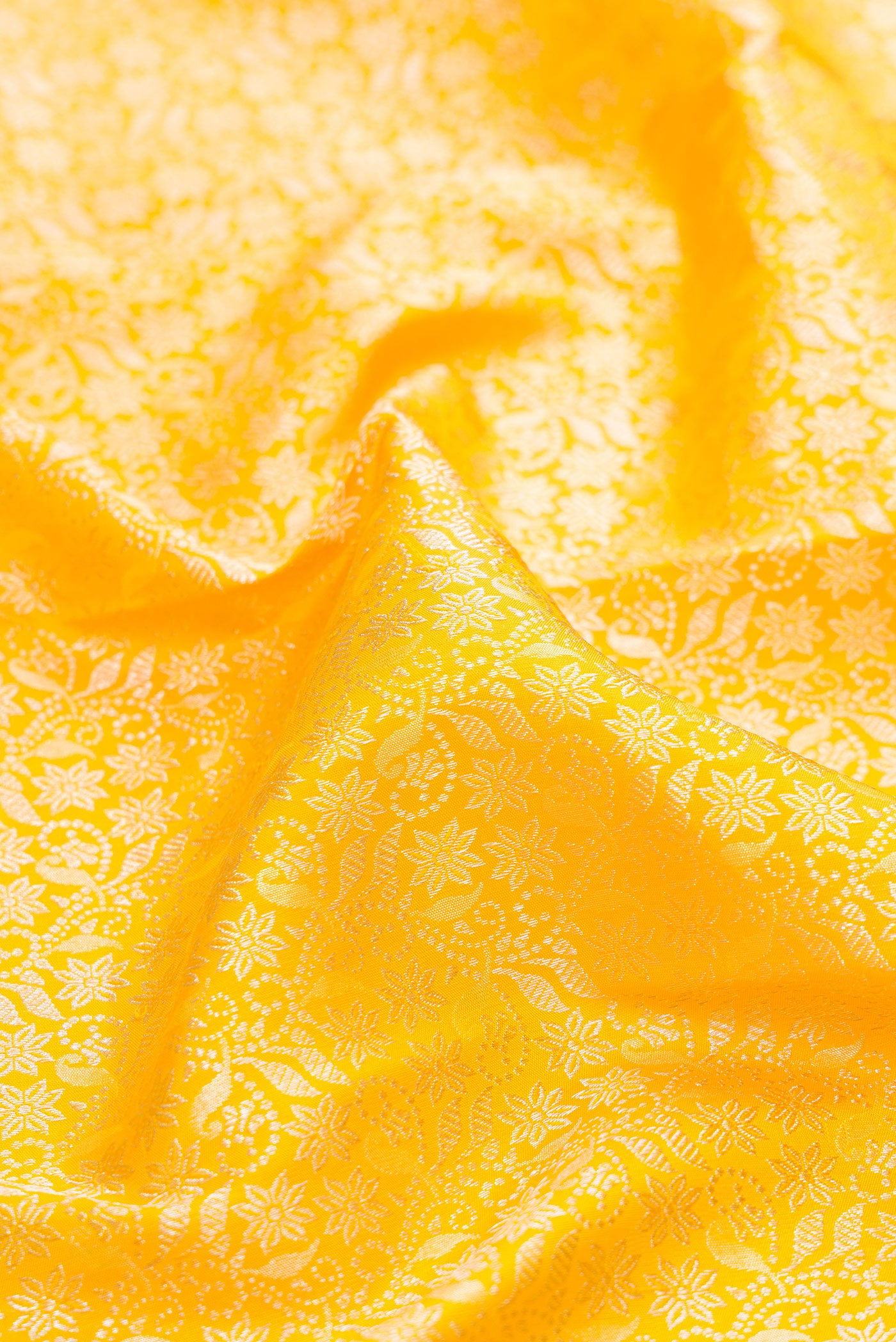 Close up of Yellow Kanchipuram Silk Saree with Zari Brocade on the body and Fancy Border.  displaying folds
