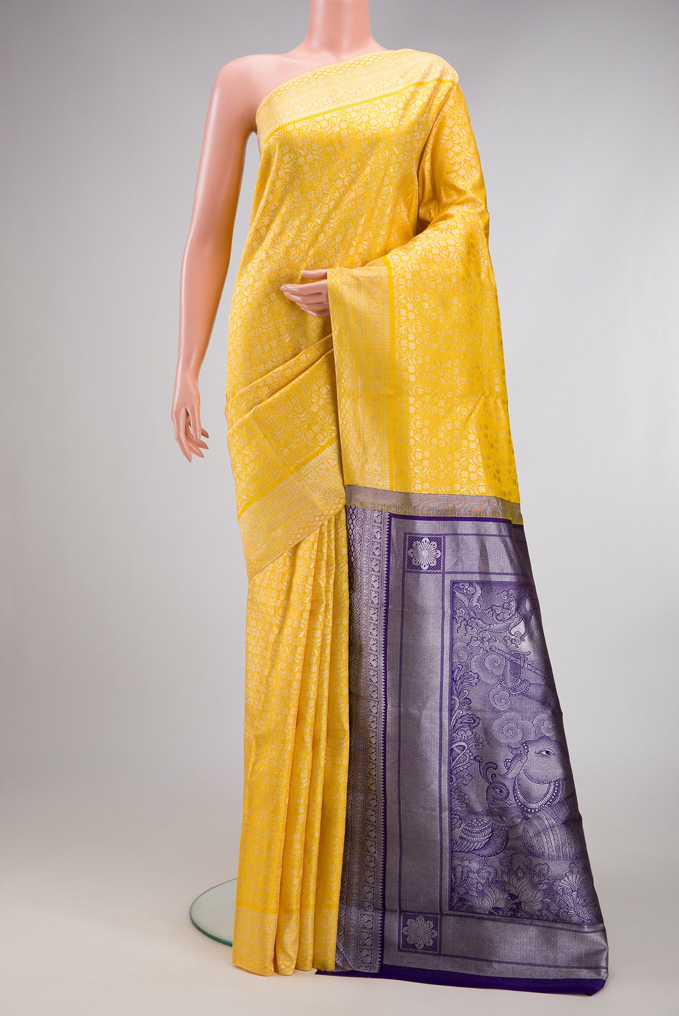 Yellow Kanchipuram Silk Saree with Zari Brocade on the body and Fancy Border.  displayed on a mannequin
