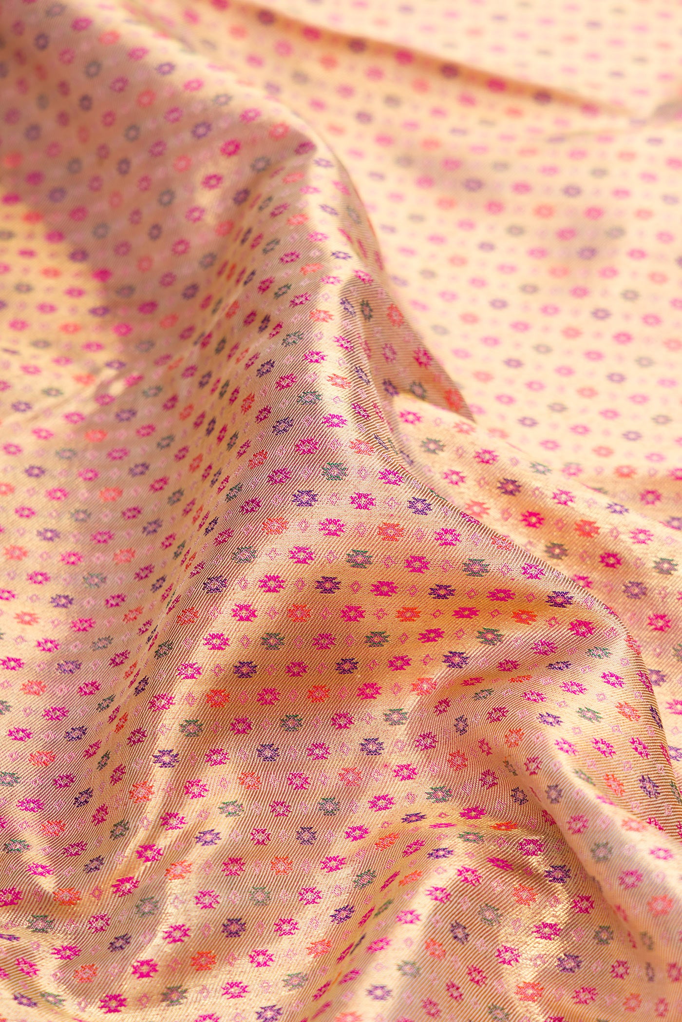 Close up of Pure Silk Pure Zari Golden Peach Dual Tone Kanjivaram Saree with Zari Brocade on the body and Zari Border.  displaying folds