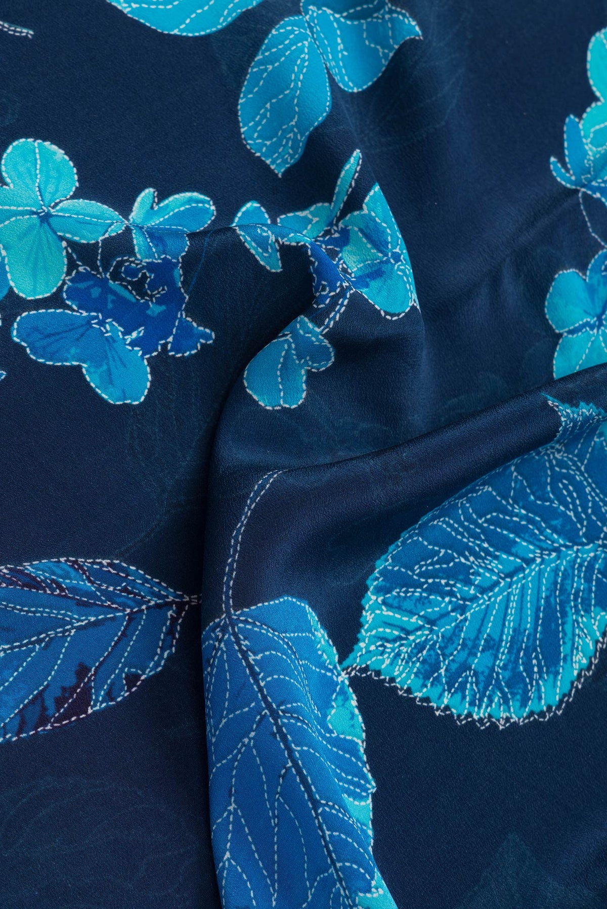 Close up of Navy Blue Dual Tone Mysore Crepe Saree with Printed design on the body and Without Border.  displaying folds