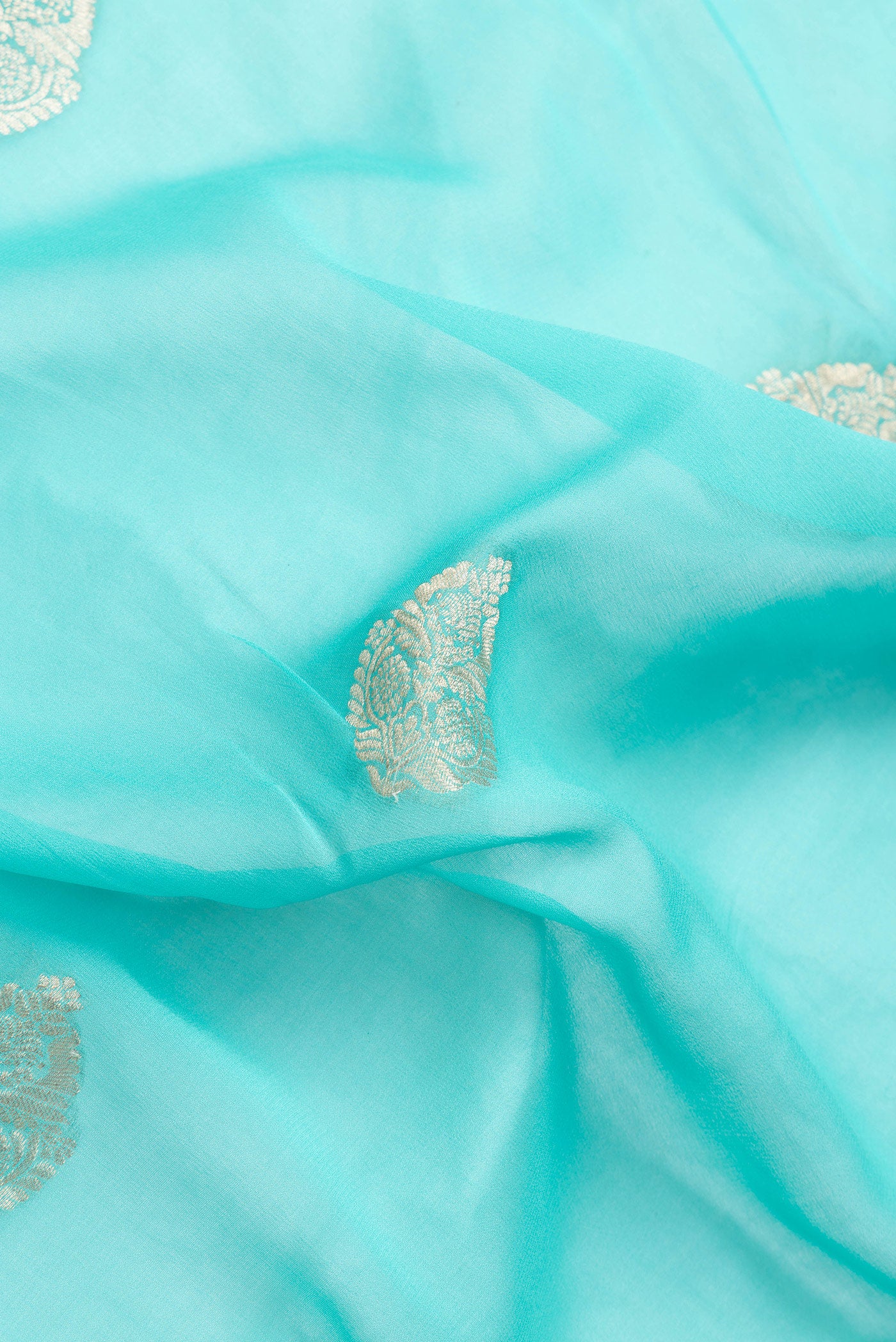 Close up of Sky Blue Dual Tone Mysore Georgette Saree with Zari Butta on the body and Zari Border.  displaying folds
