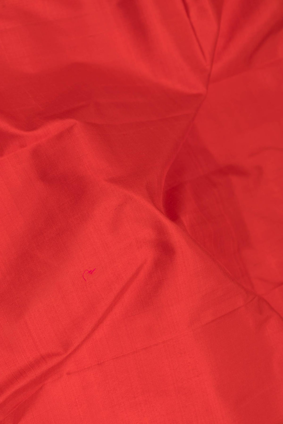 Close up of Red Dual Tone Kanchipuram Saree with Plain Body and Zari Border displaying folds
