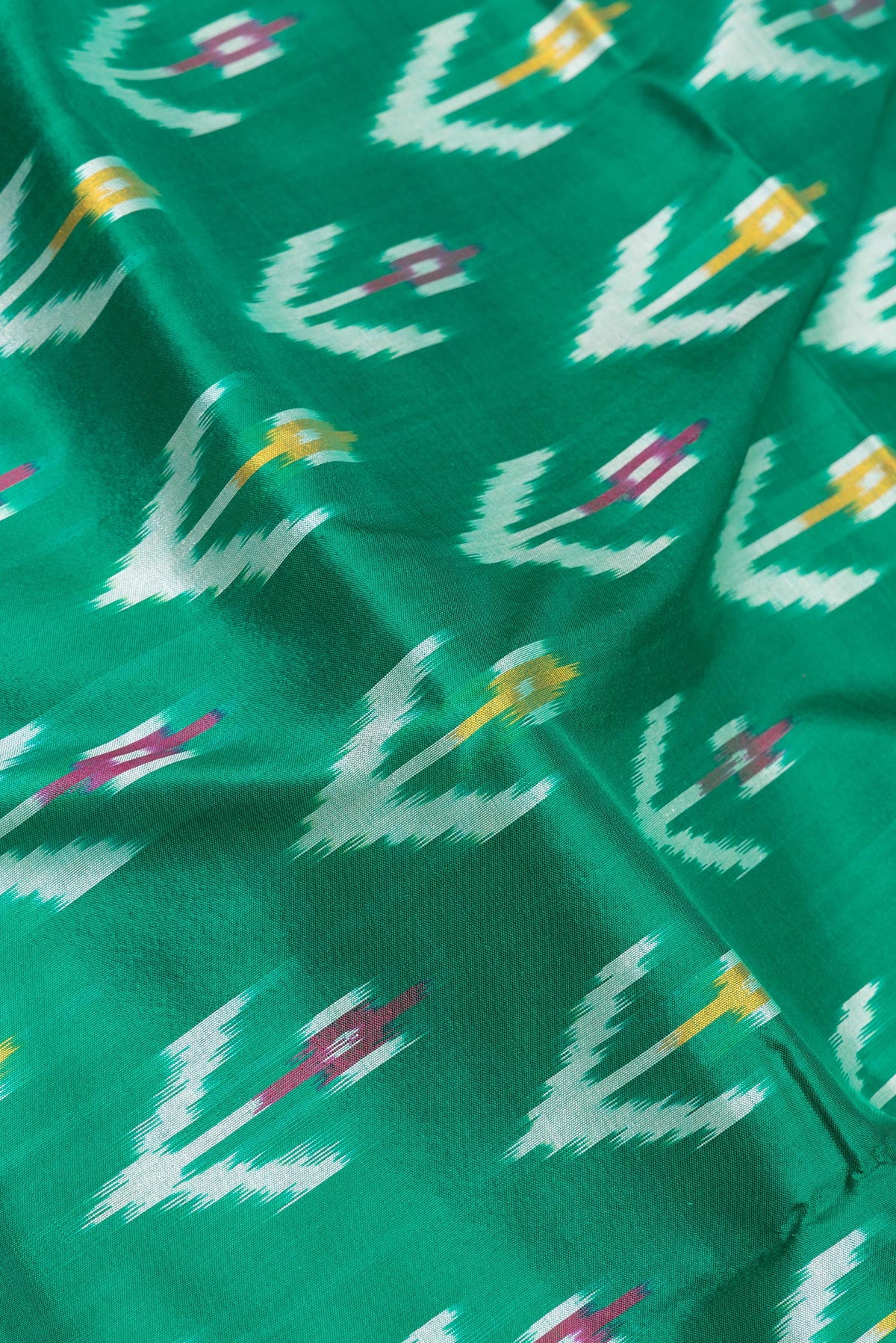 Close up of Pure Silk Green Pochampally Saree with Ikat design on the body and Ikat Border.  displaying folds