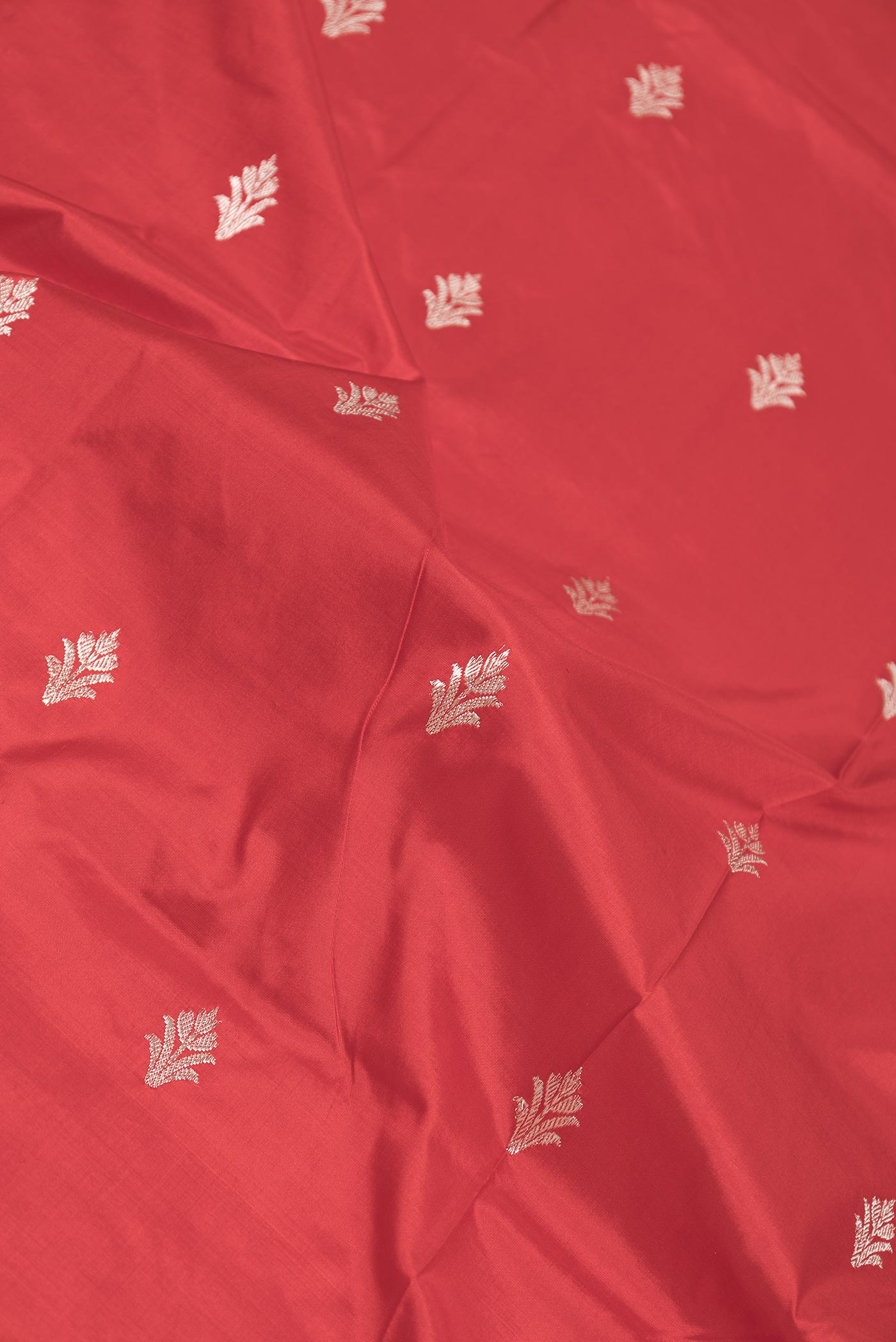 Close up of Red Dual Tone Banarasi Silk Saree with Zari Butta on the body and Zari Border displaying folds