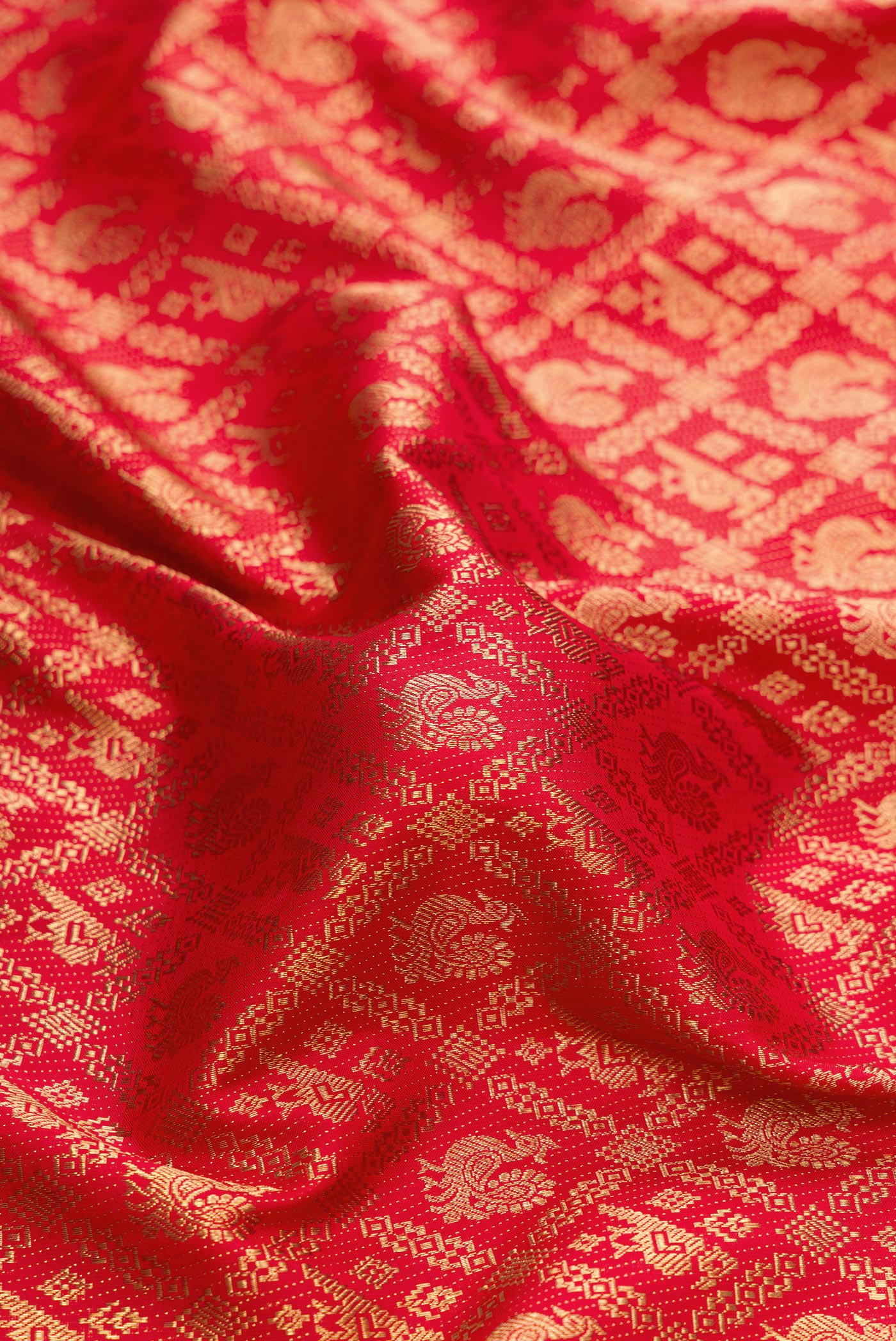 Close up of Pure Silk Pure Zari Red Dual Tone Kanjivaram Saree with Zari Brocade on the body and Zari Border.  displaying folds