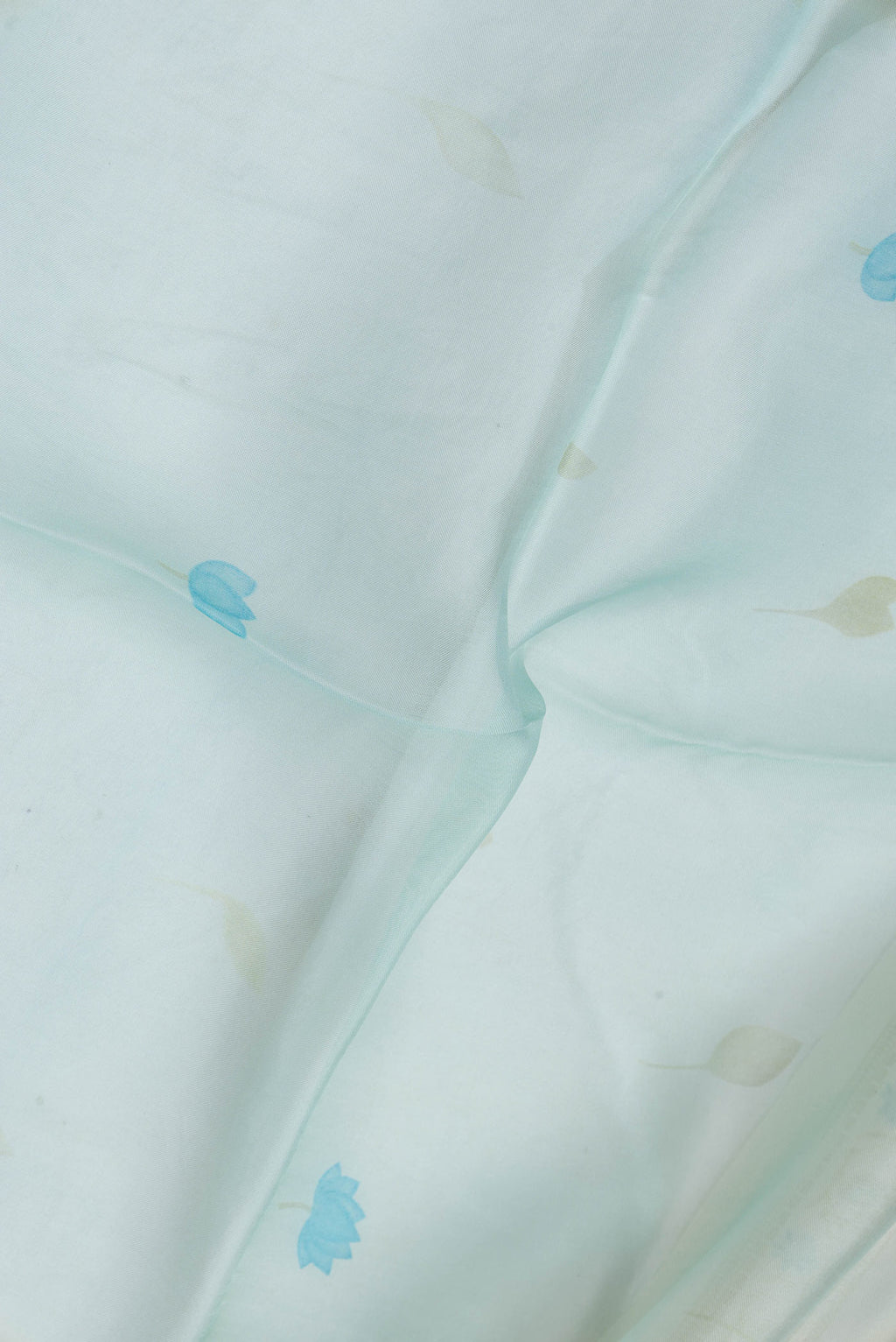 Close up of Light Blue Dual Tone Organza Silk Saree with Embroidery on the body and Embroidery Border.  displaying folds
