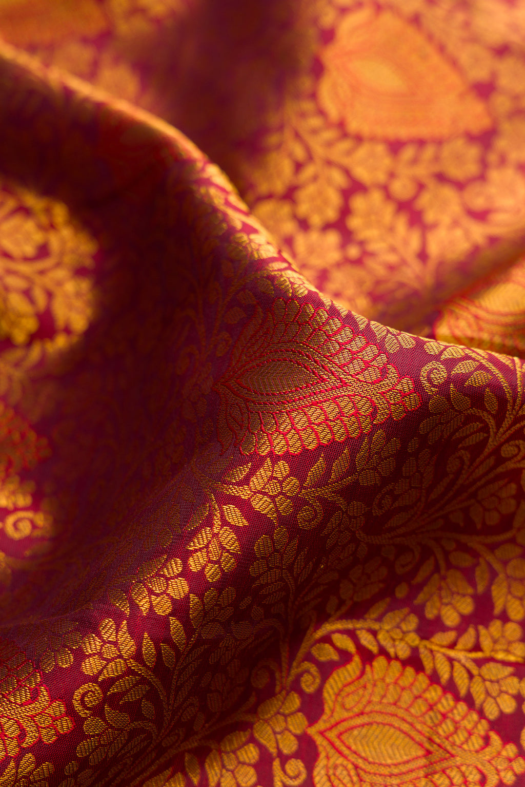 Close up of Maroon Dual Tone Kanjivaram Silk Saree with Zari Brocade on the body and Zari Border.  displaying folds