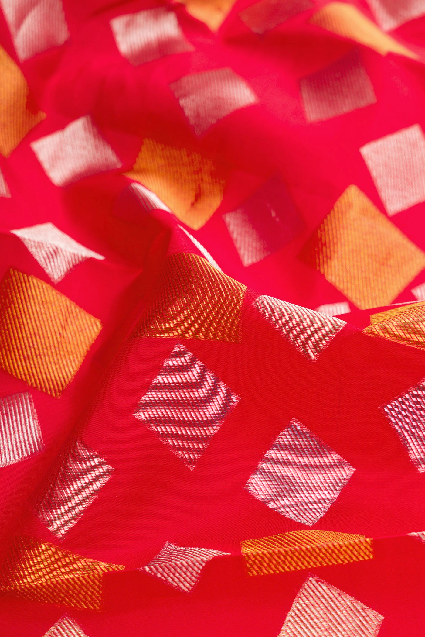 Close up of Red Dual Tone Kanchipuram Silk Saree with Zari Brocade on the body and Zari Border.  displaying folds