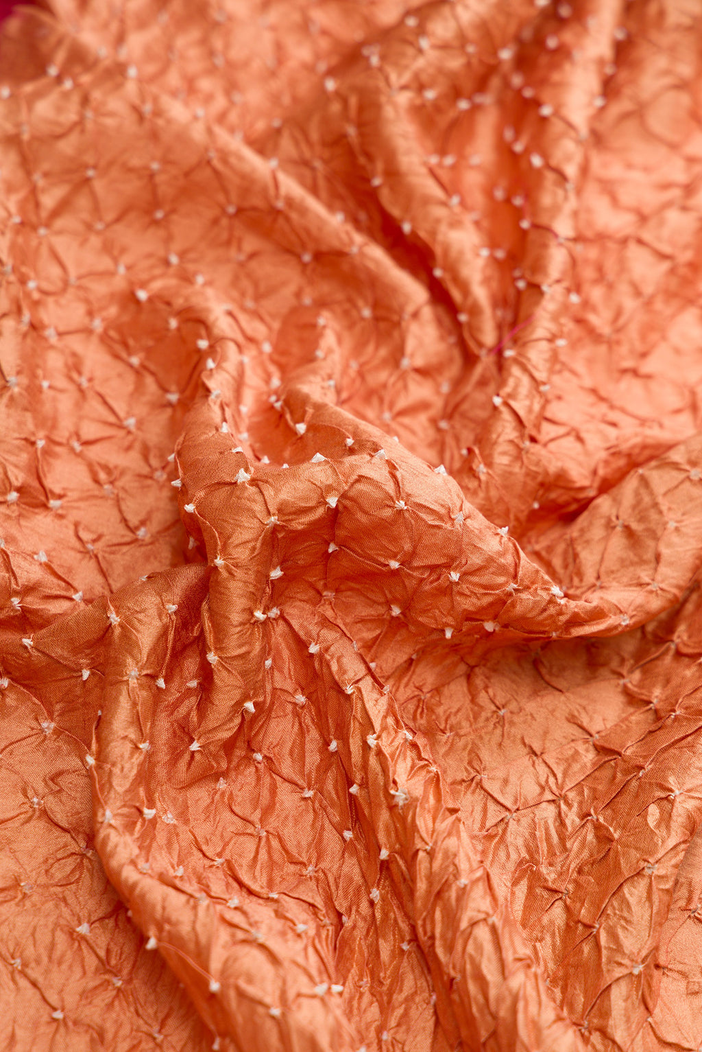Close up of Brown Dual Tone Bandhani Silk Saree with Bandhani Print on the body and Zari Border.  displaying folds