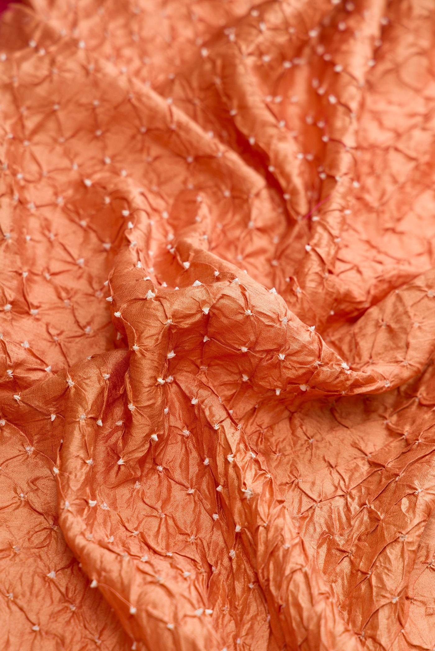 Close up of Brown Dual Tone Bandhani Silk Saree with Bandhani Print on the body and Zari Border.  displaying folds