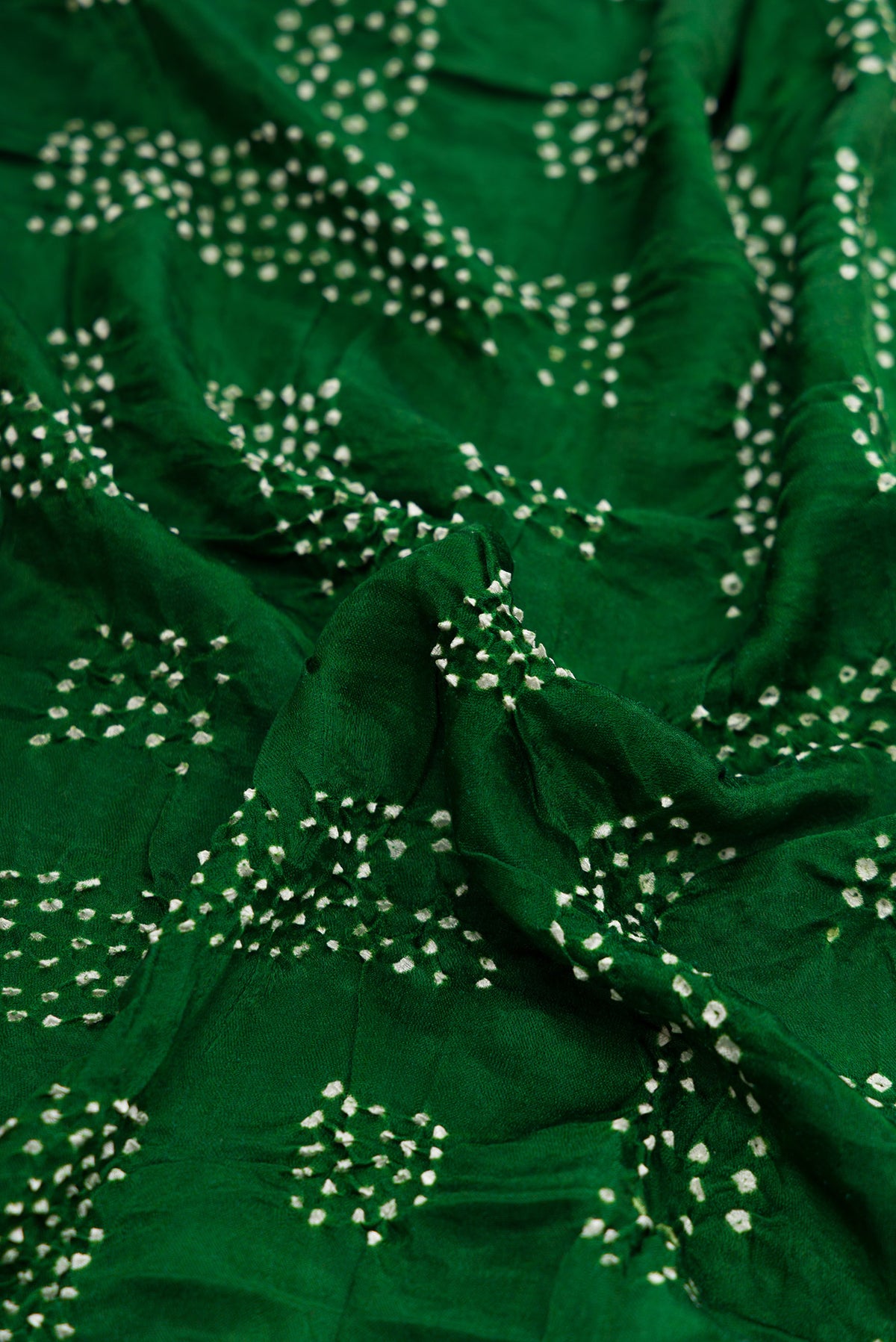 Close up of Bottle Green Dual Tone Bandhani Silk Saree with Printed design on the body and Printed Border.  displaying folds