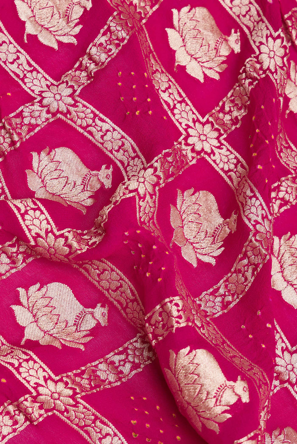 Close up of Dark Pink Bandhani Georgette Saree with Zari Brocade on the body and Zari Border.  displaying folds