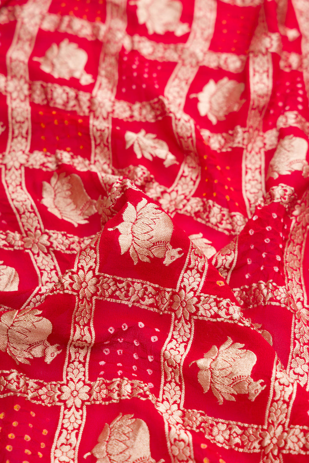 Close up of Red Dual Tone Bandhani Silk Saree with Zari Brocade on the body and Zari Border.  displaying folds