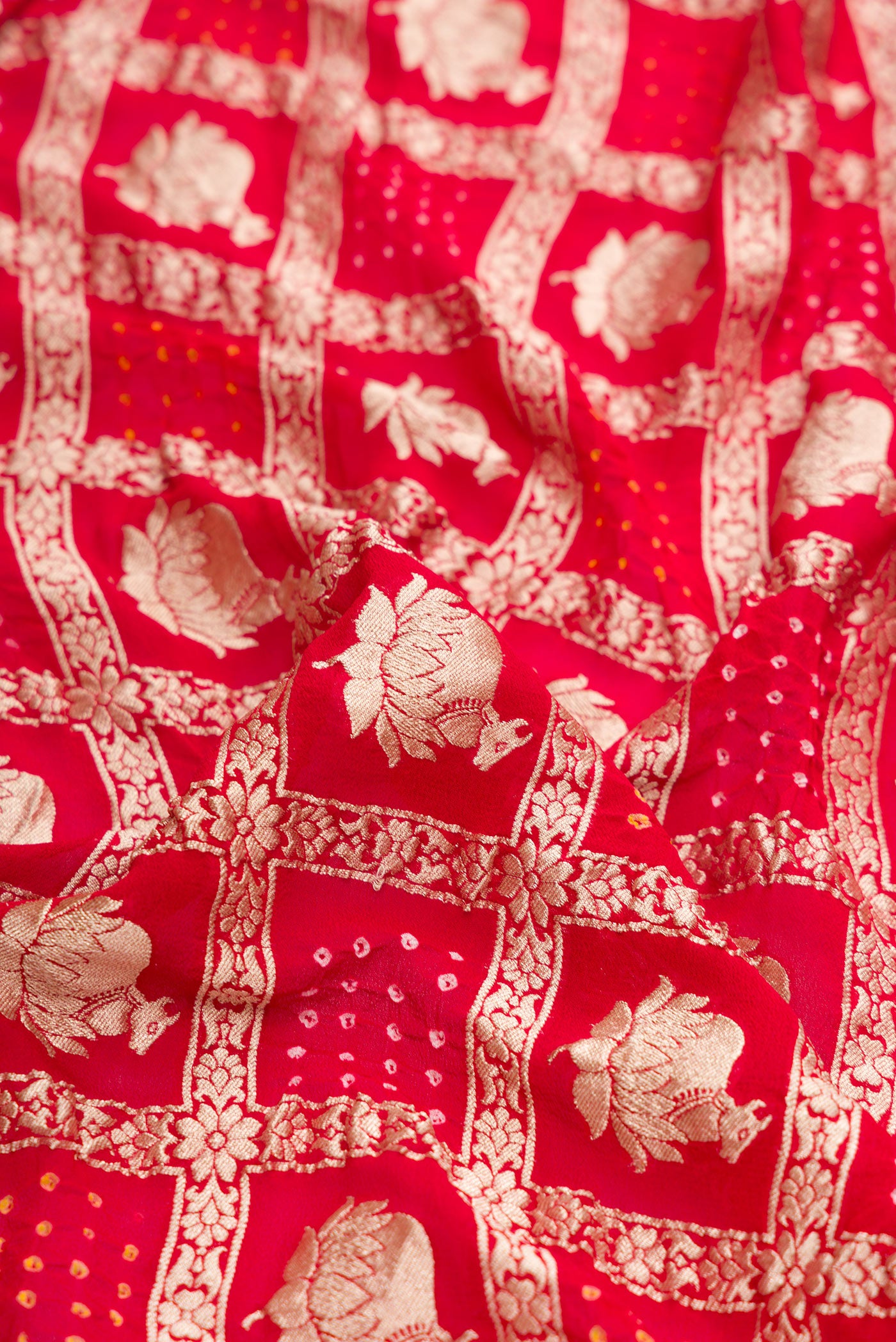 Close up of Red Dual Tone Bandhani Silk Saree with Zari Brocade on the body and Zari Border.  displaying folds