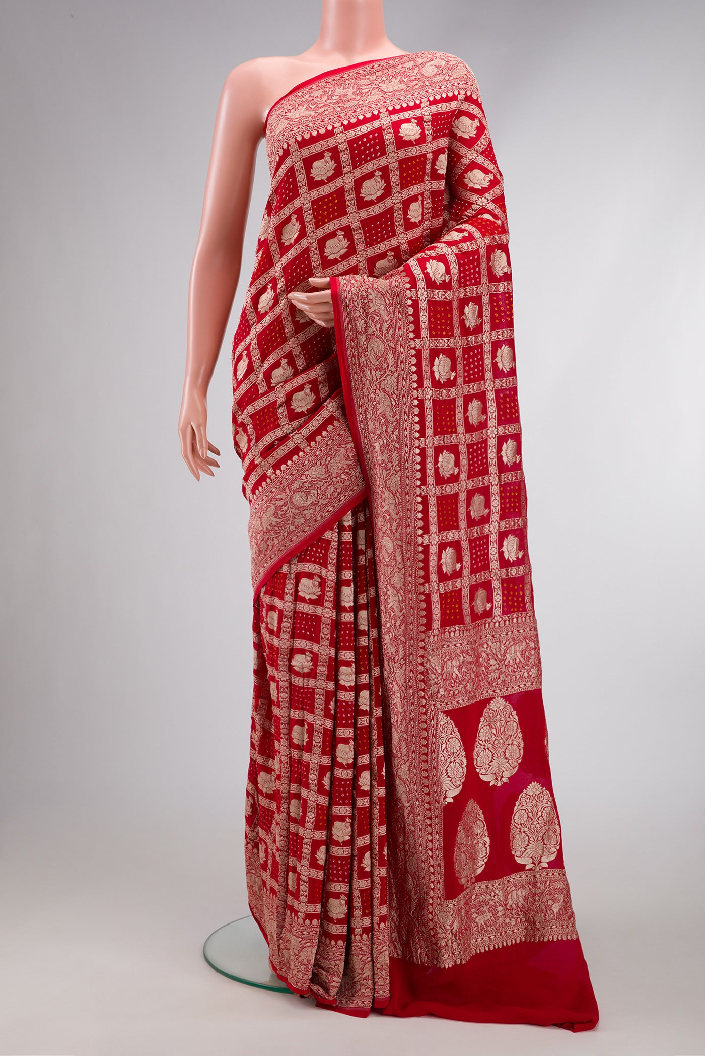 Red Dual Tone Bandhani Silk Saree with Zari Brocade on the body and Zari Border.  displayed on a mannequin