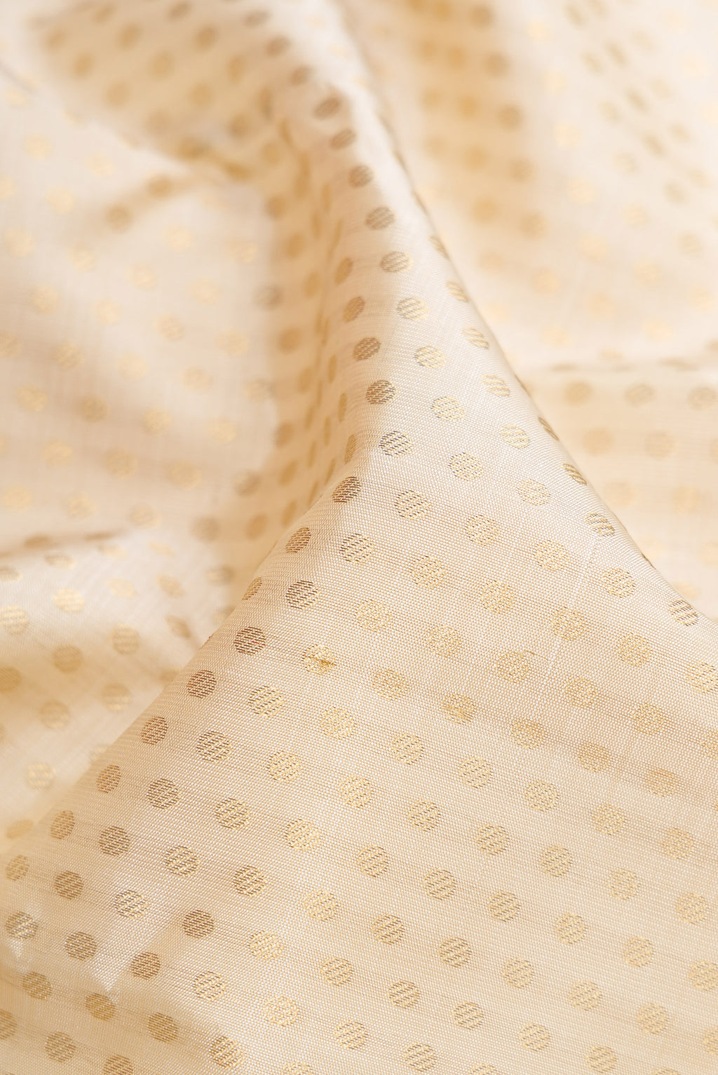 Close up of Pure Silk Pure Zari Off White Dual Tone Kanjivaram Saree with Zari Brocade on the body and Zari Border.  displaying folds