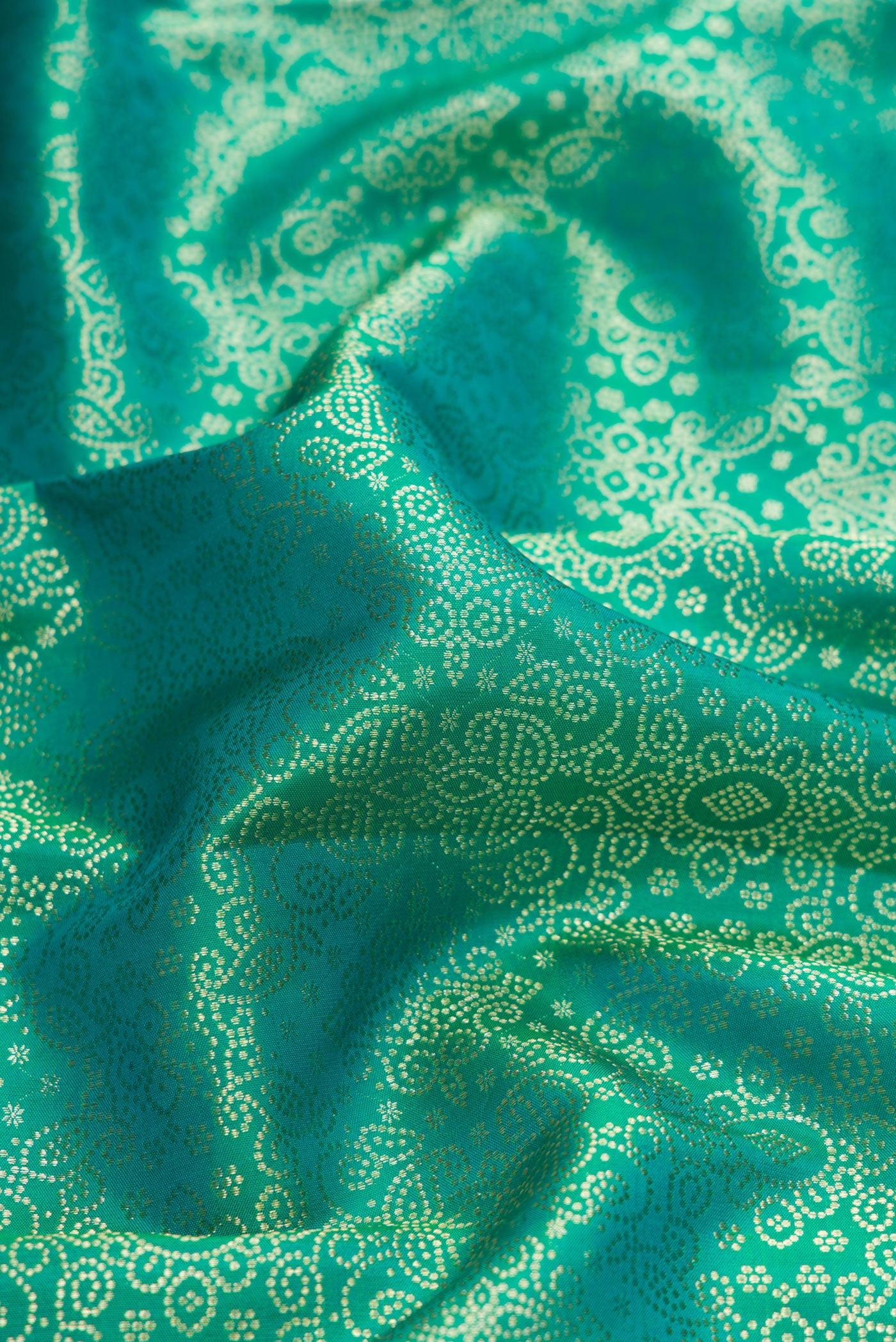 Close up of Green Dual Tone Kanchipuram Silk Saree with Zari Brocade on the body and Zari Border.  displaying folds
