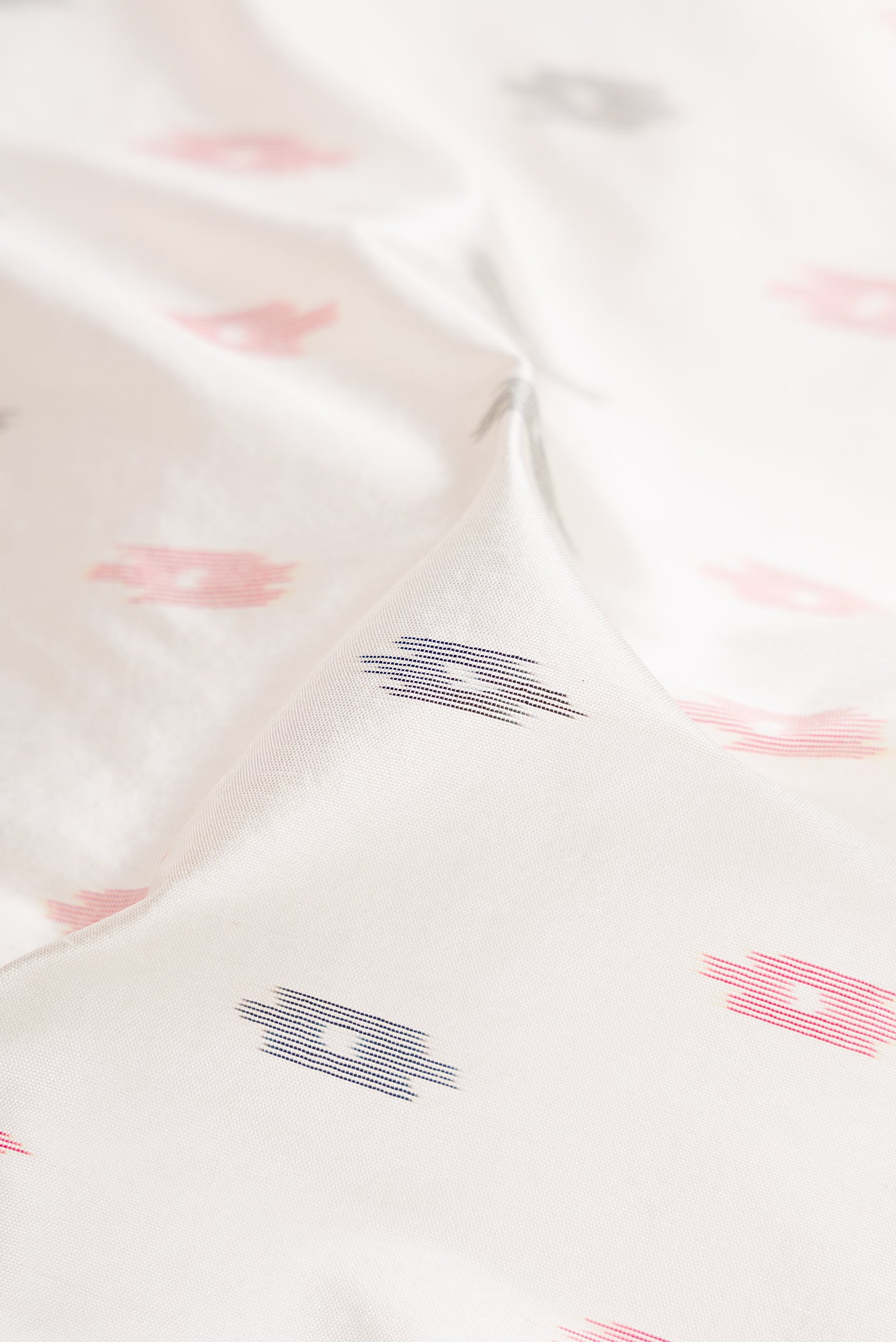 Close up of White Double Ikat Saree with Ikat Print on the body and Temple Border.  displaying folds