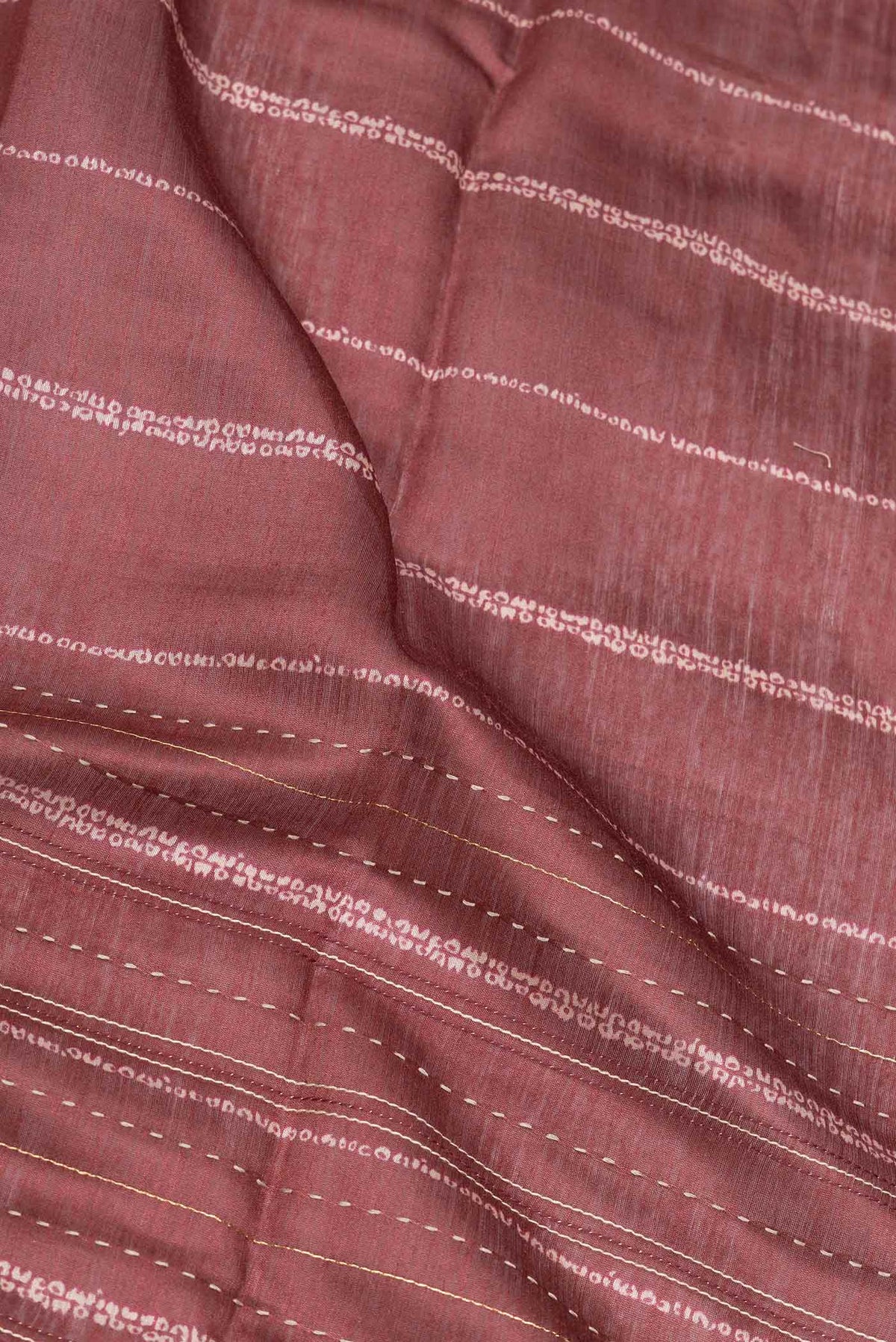 Close up of Maroon Dual Tone Tussar Silk Saree with Embroidery on the body and Embroidery Border displaying folds