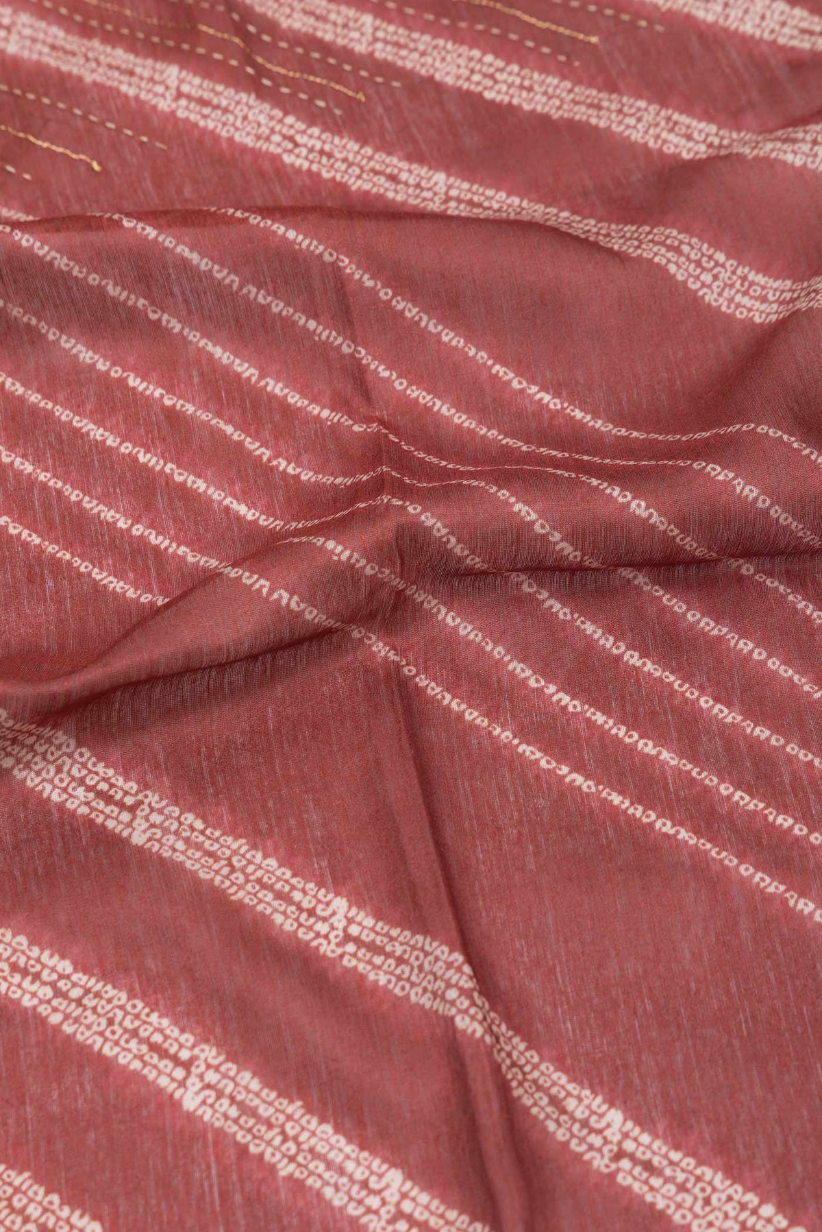 Close up of Orange Dual Tone Tussar Silk Saree With Printed design on the body and Zari Border displaying folds