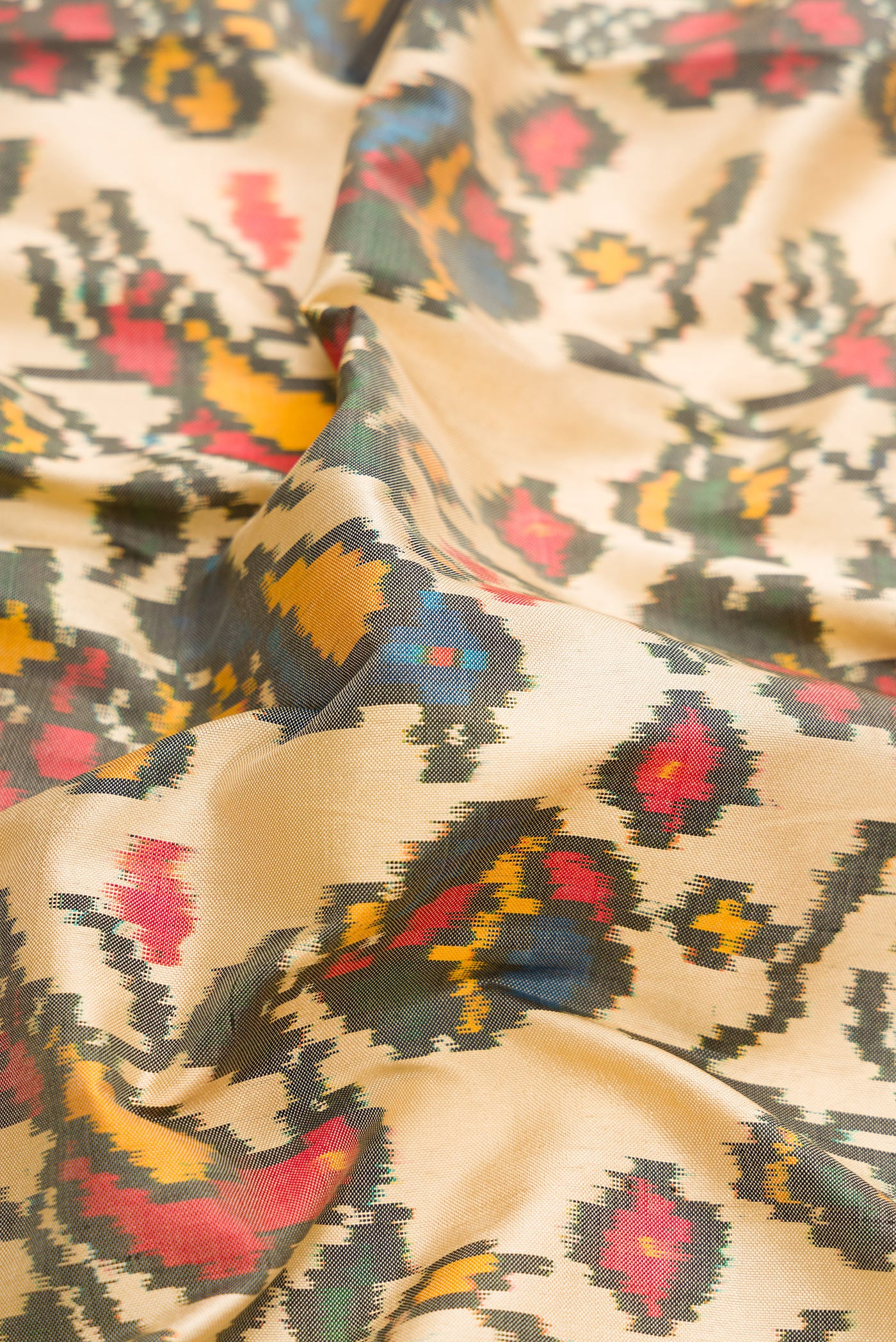 Close up of Sandal Dual Tone Double Ikat Saree with Ikat Print on the body and Zari Border.  displaying folds