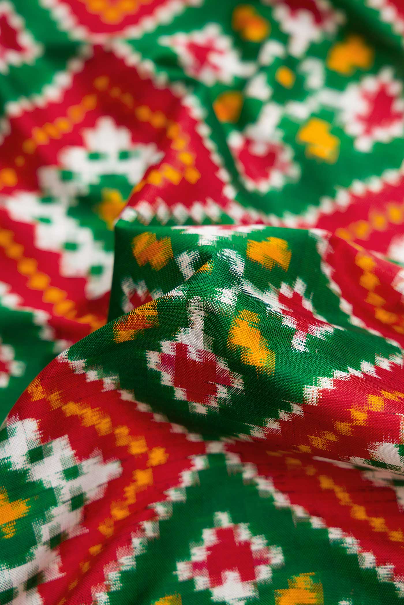Close up of Green Pochampally Silk Saree with Pure Ikat on the body and Zari Border displaying folds