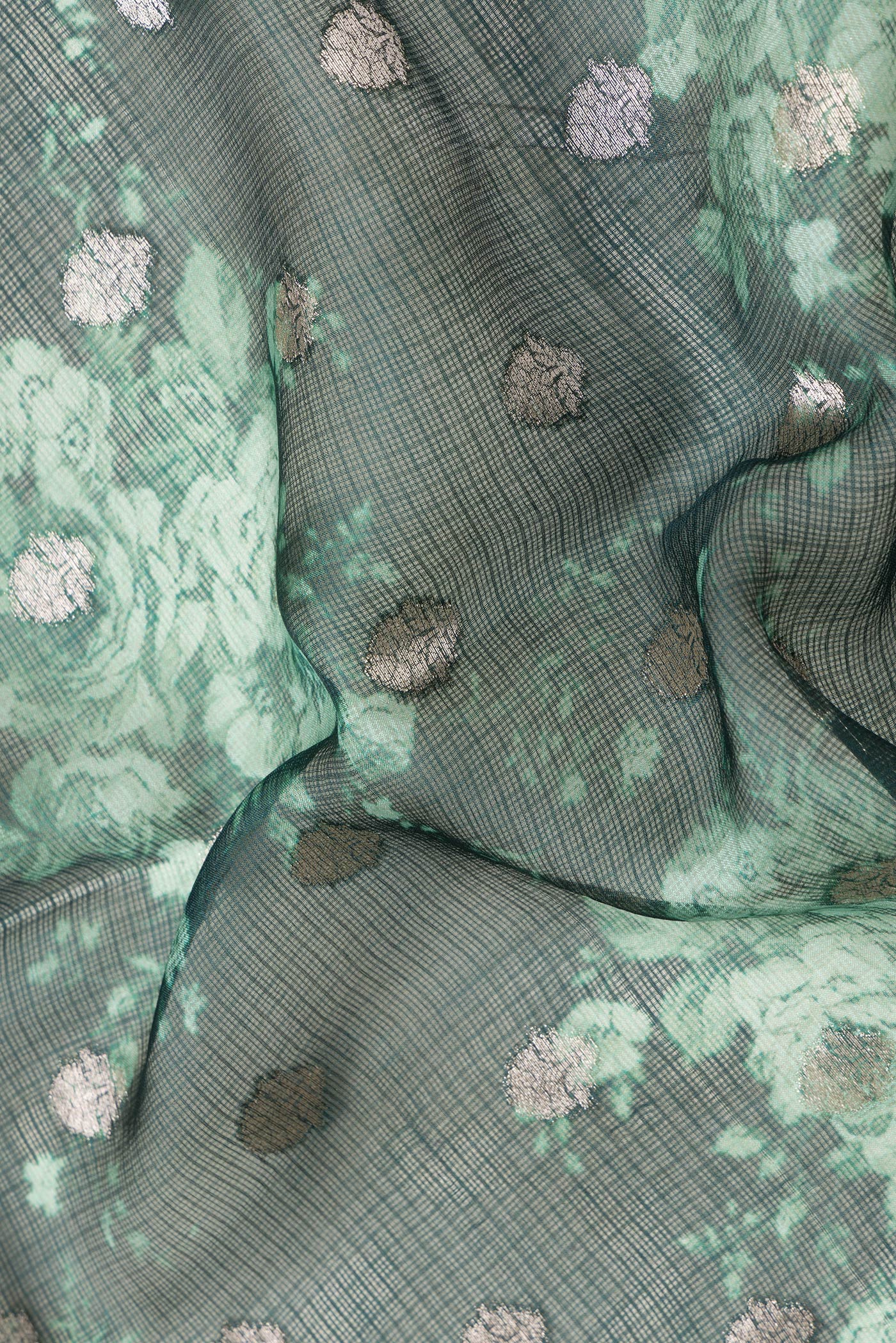 Close up of Green Dual Tone Kota Silk Saree with Zari Butta on the body and Zari And Thread Border.  displaying folds