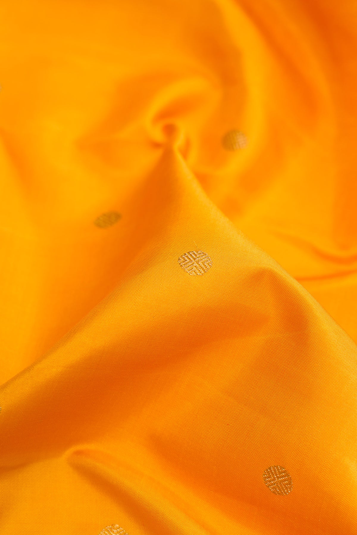Close up of Yellow Kanchipuram Silk Saree with Zari Butta on the body and Zari Border.  displaying folds