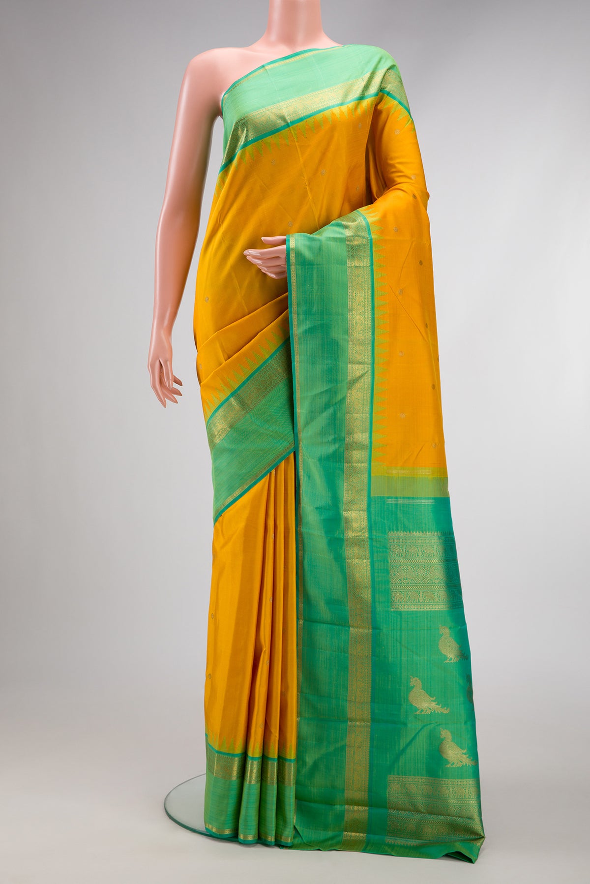 Yellow Kanchipuram Silk Saree with Zari Butta on the body and Zari Border.  displayed on a mannequin