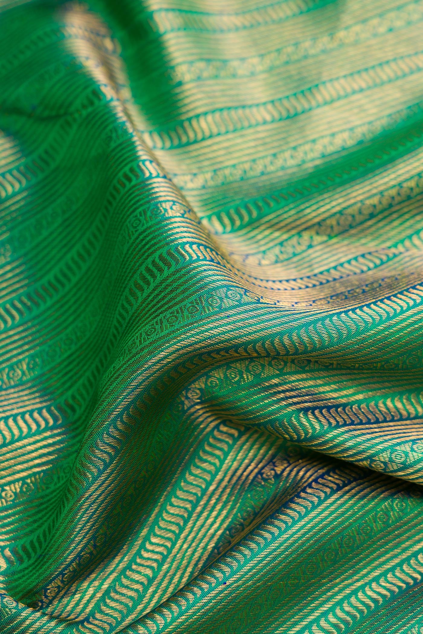 Close up of Green Dual Tone Kanchipuram Silk Saree with Zari Brocade on the body and Zari Border.  displaying folds