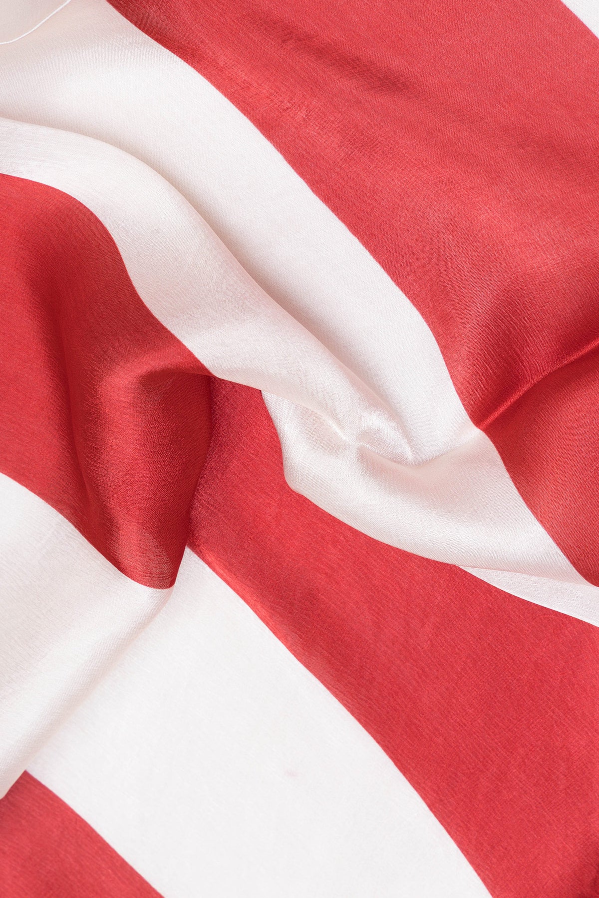 Close up of Red Crepe Saree with Printed design on the body and Without Border.  displaying folds