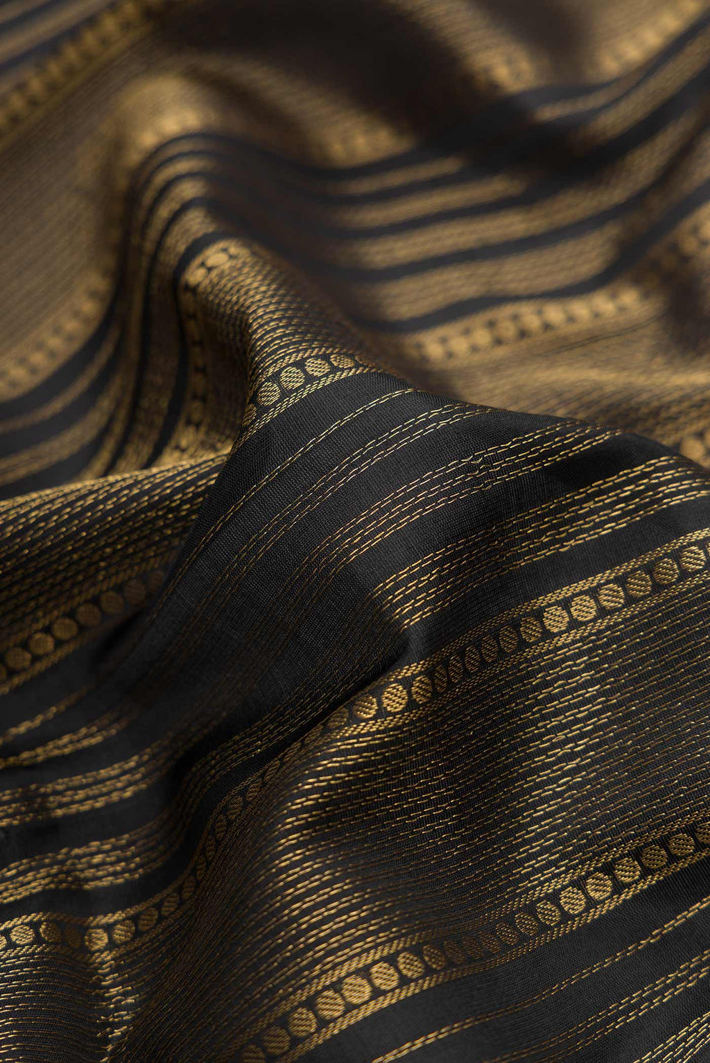 Close up of Black Dual Tone Soft Silk Saree with Stripes on the body and Zari Border.  displaying folds