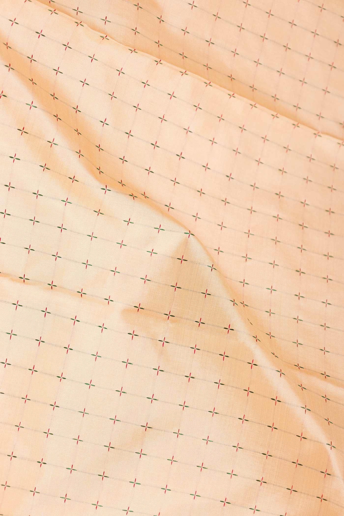Close up of Golden Peach Dual Tone Kanchipuram Silk Saree with Checked design on the body and Ganga Jamuna Border displaying folds