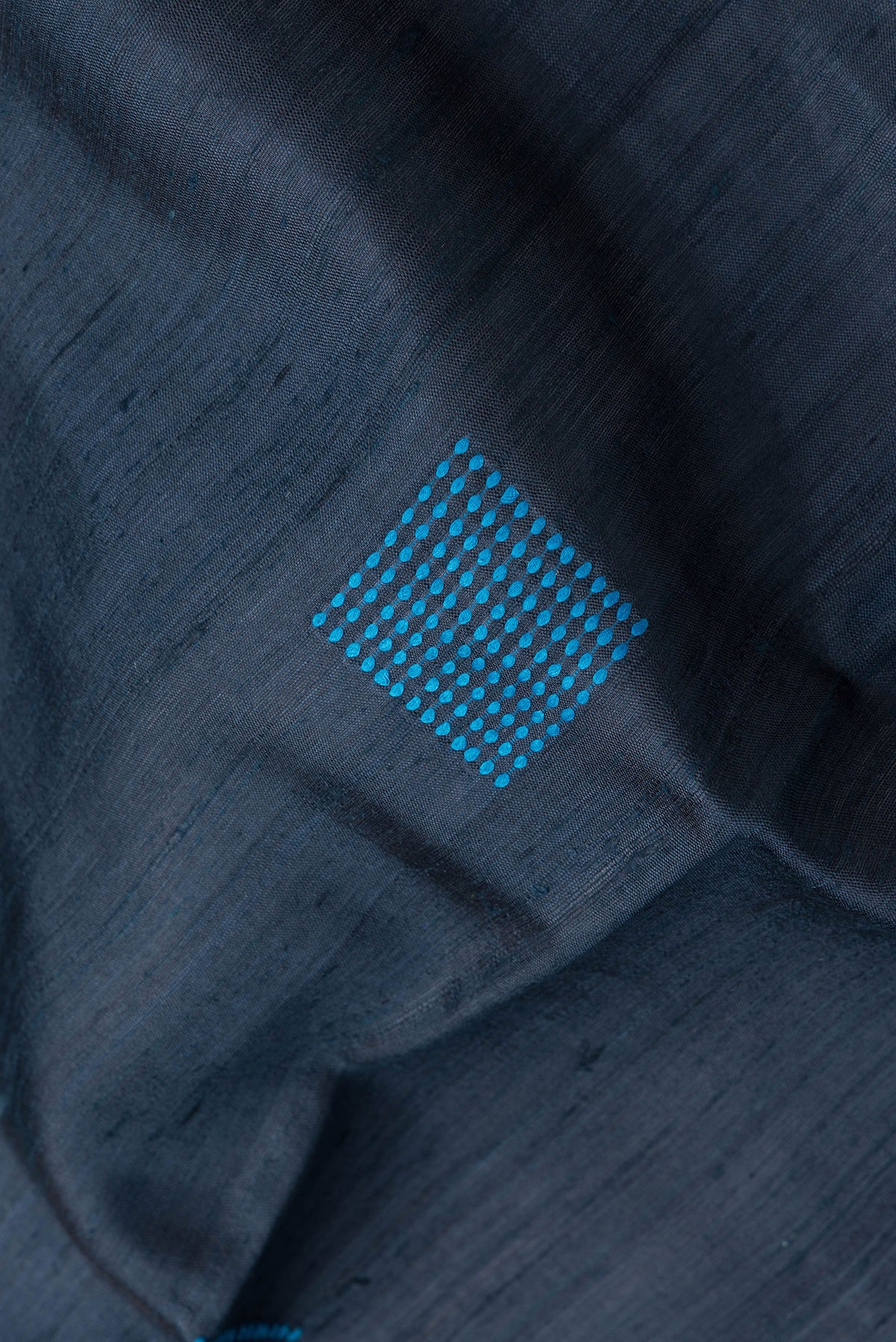 Close up of Peacock Blue Dual Tone Tussar Silk Saree with Thread Butta on the body and Zari Border.  displaying folds
