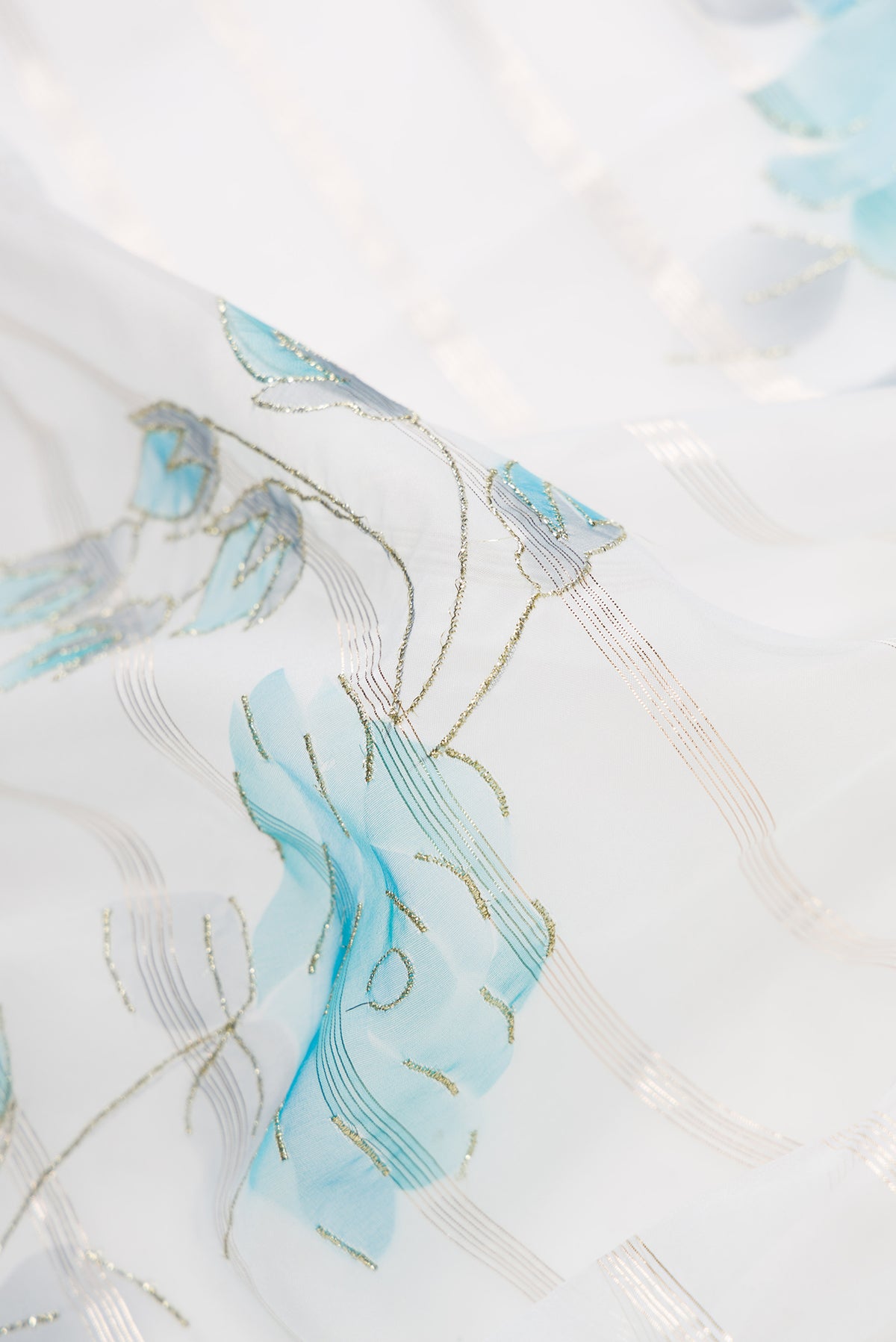 Close up of Off White Dual Tone Organza Silk Saree with Stripes on the body and Embroidery Border.  displaying folds