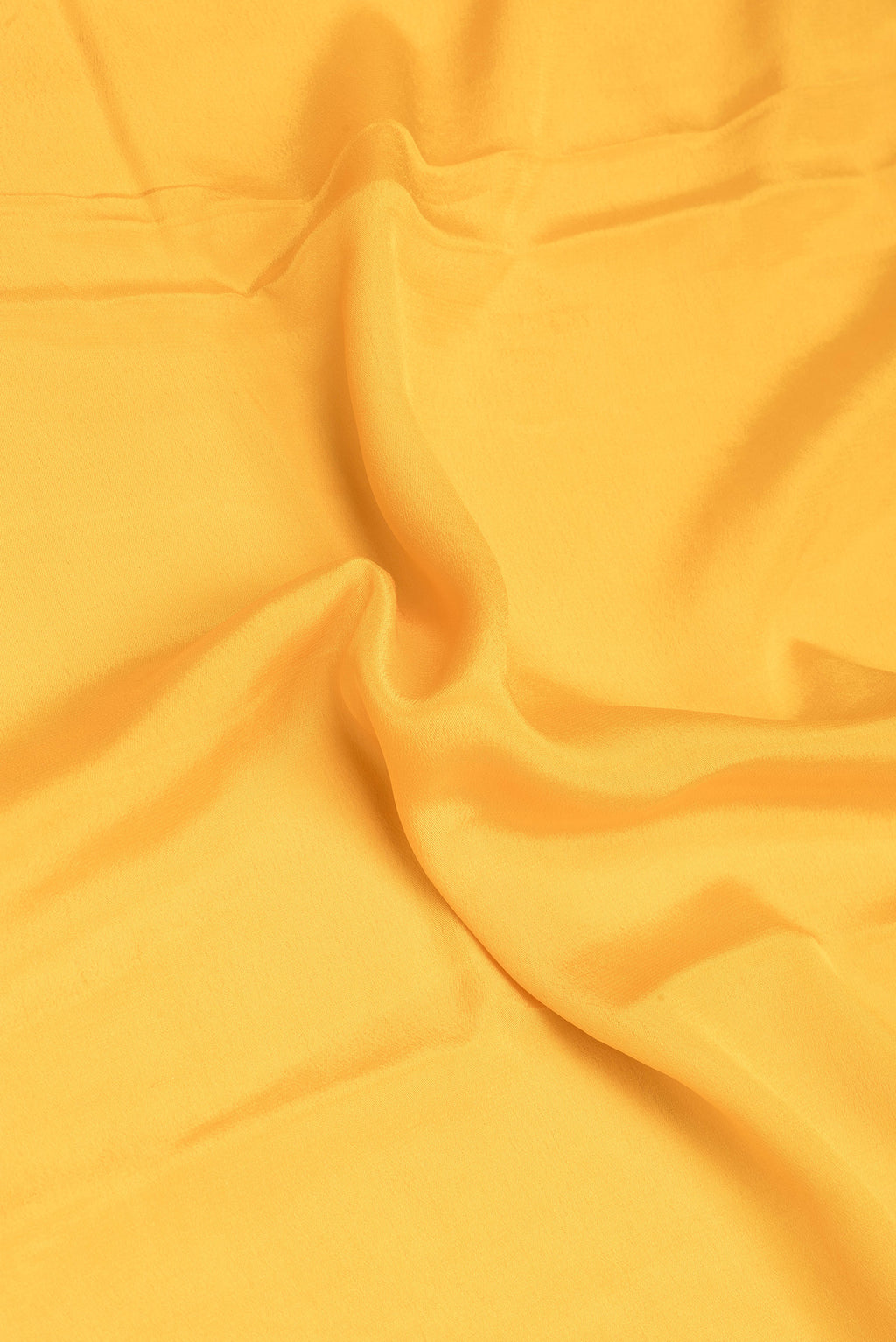Close up of Yellow Banarasi Georgette Saree with Plain Body and Zari Border.  displaying folds