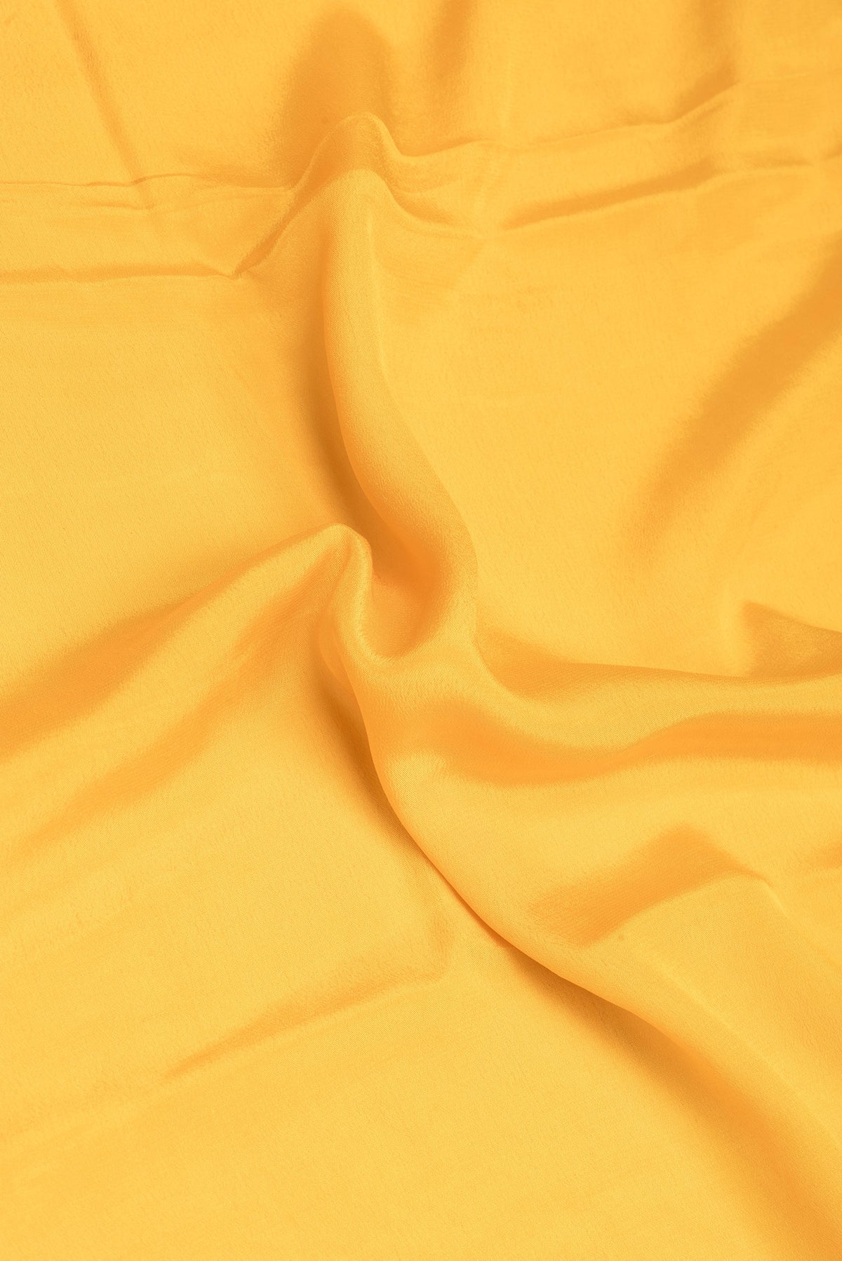Close up of Yellow Banarasi Georgette Saree with Plain Body and Zari Border.  displaying folds