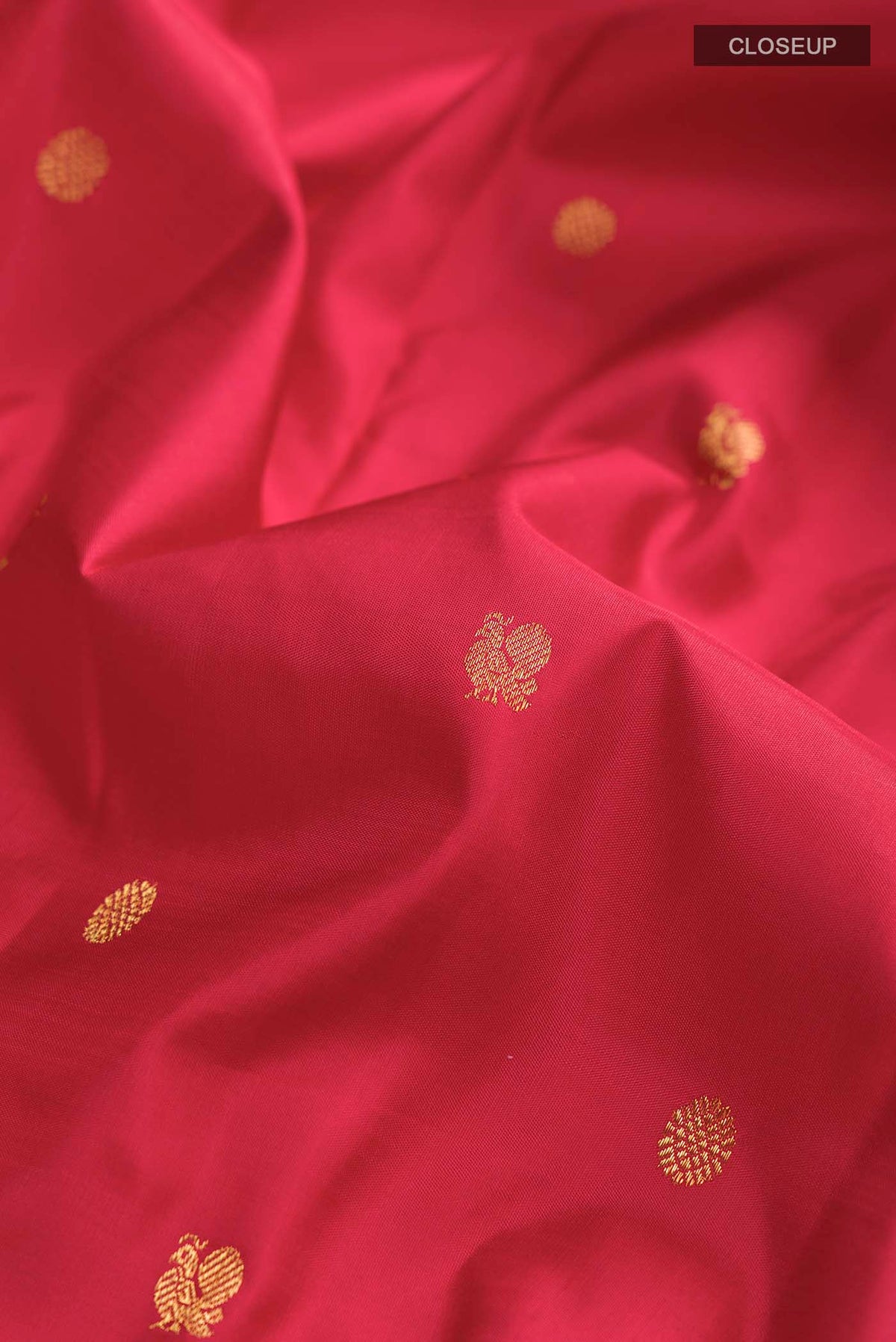 Close up of Red Kanchipuram Silk Saree with Zari Butta on the body and Zari Border displaying folds