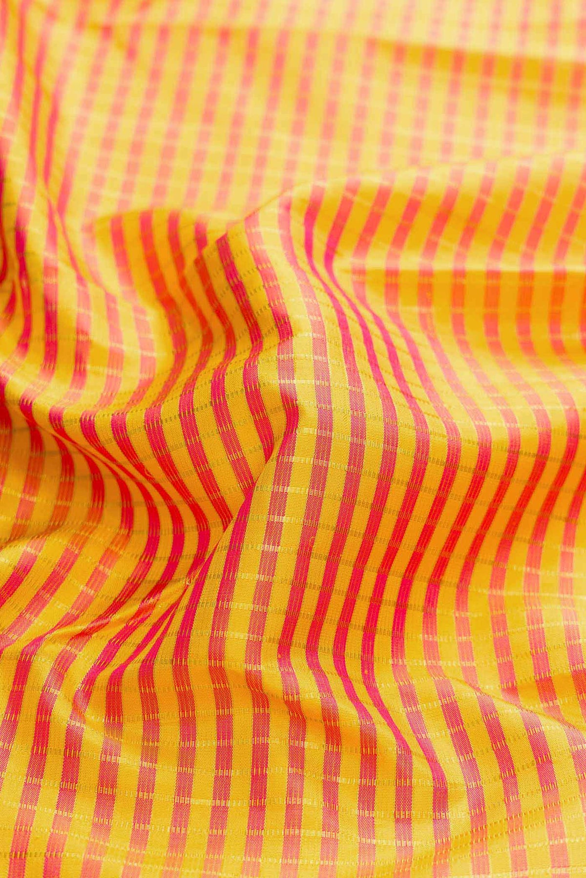Close up of Yellow Dual Tone Kanchipuram Silk Saree with Checked design on the body and Fancy Border displaying folds