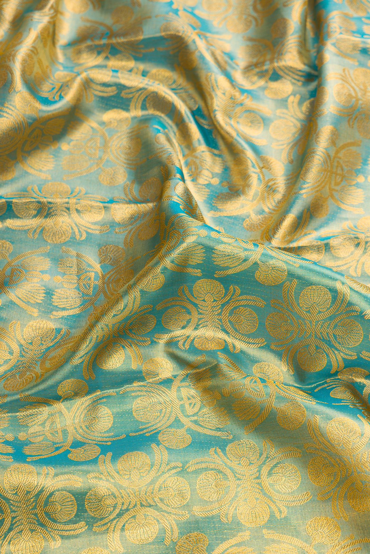 Close up of Sky Blue Dual Tone Kanchipuram Tissue Silk Saree with Zari Brocade on the body and Zari Border.  displaying folds