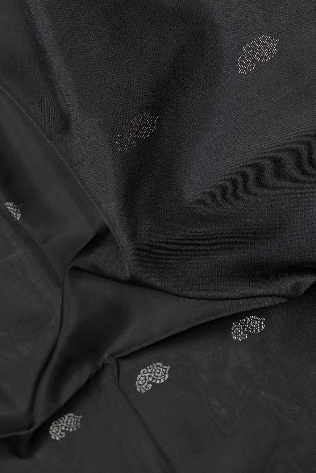 Close up of Black Dual Tone Soft Silk Saree with Zari Butta on the body and Zari Border.  displaying folds